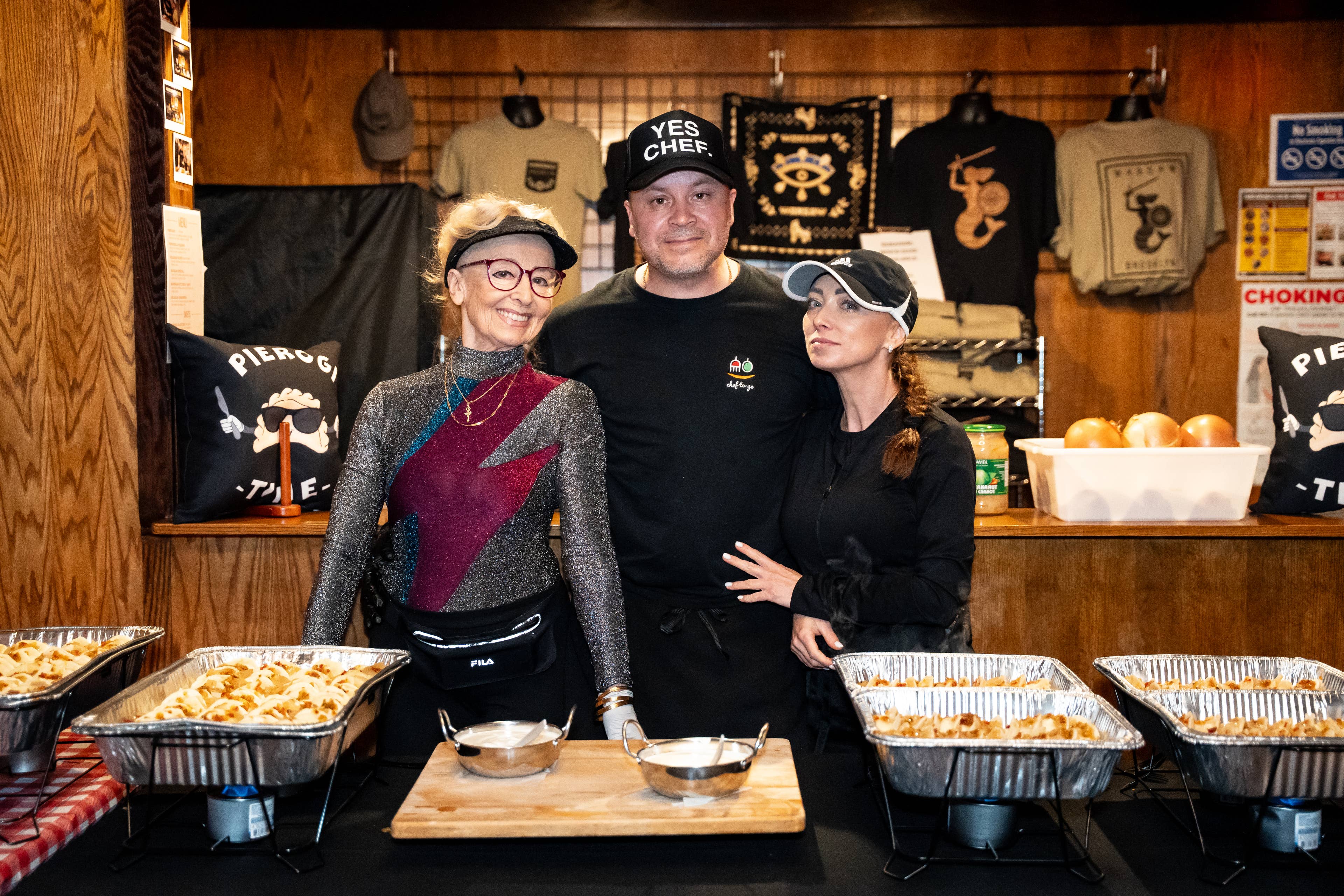 a photo of 3 of employees smiling and posing behind trays of pierogis in the Warsaw Bistro