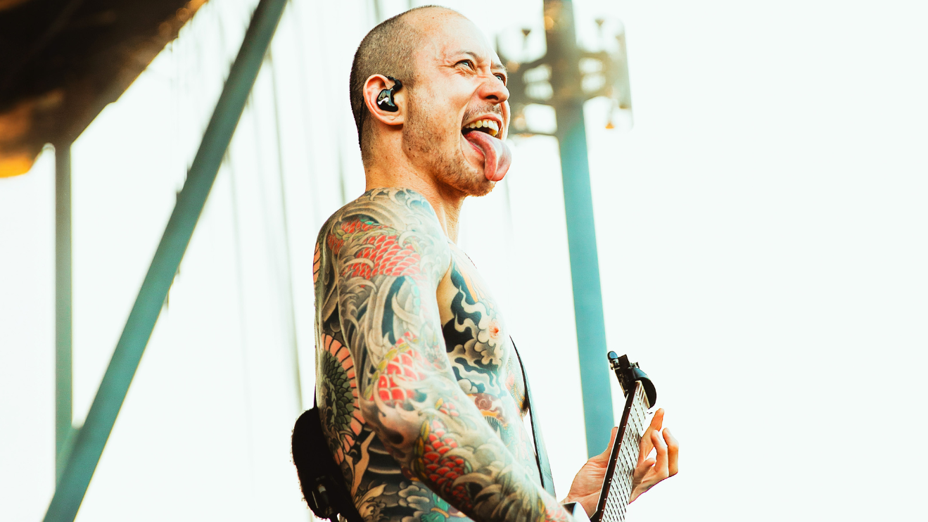 A photo of the Trivium guitar player sticking his tongue out at Skyla Credit Union Amphitheatre.