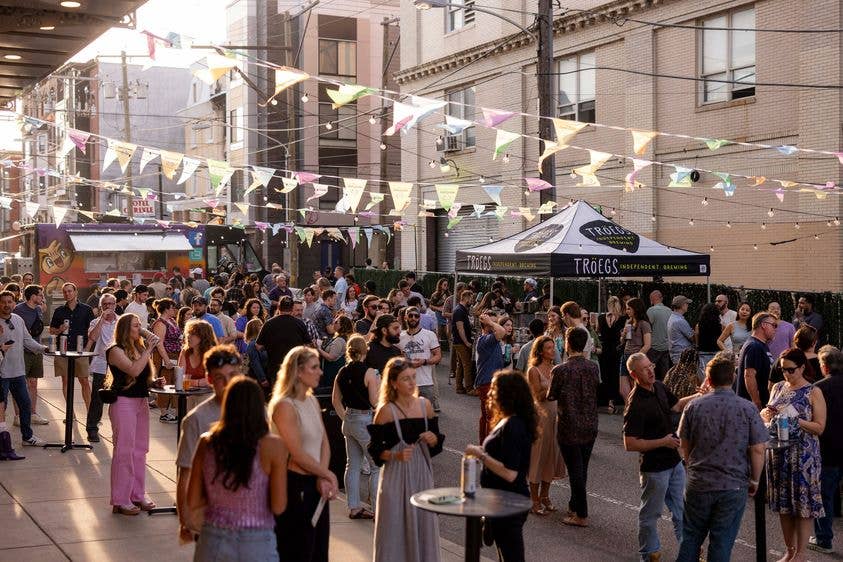 People on the streets with a tent booth on the side