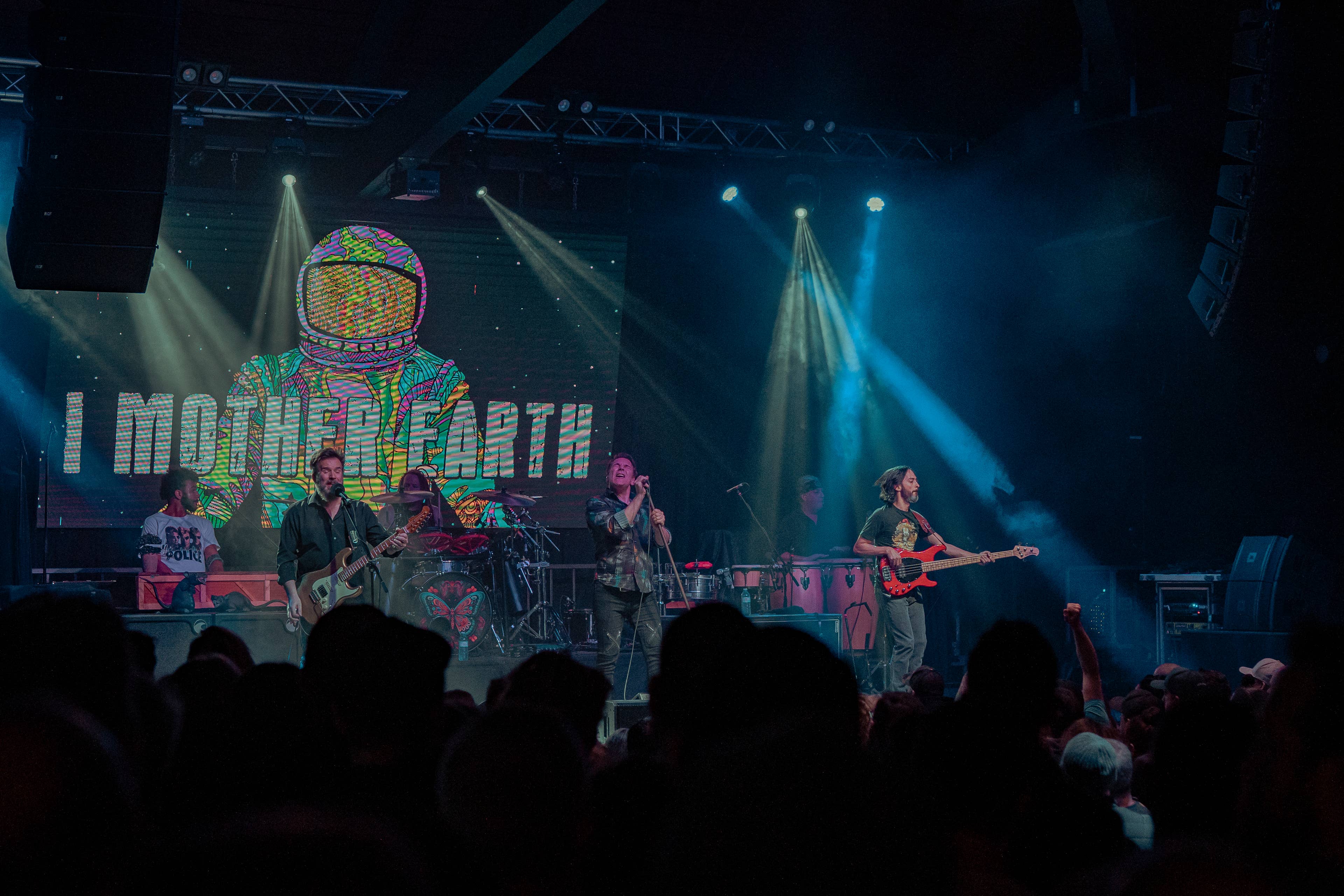 view of a band on stage at  midway music hall with a banner that says "i mother earth"