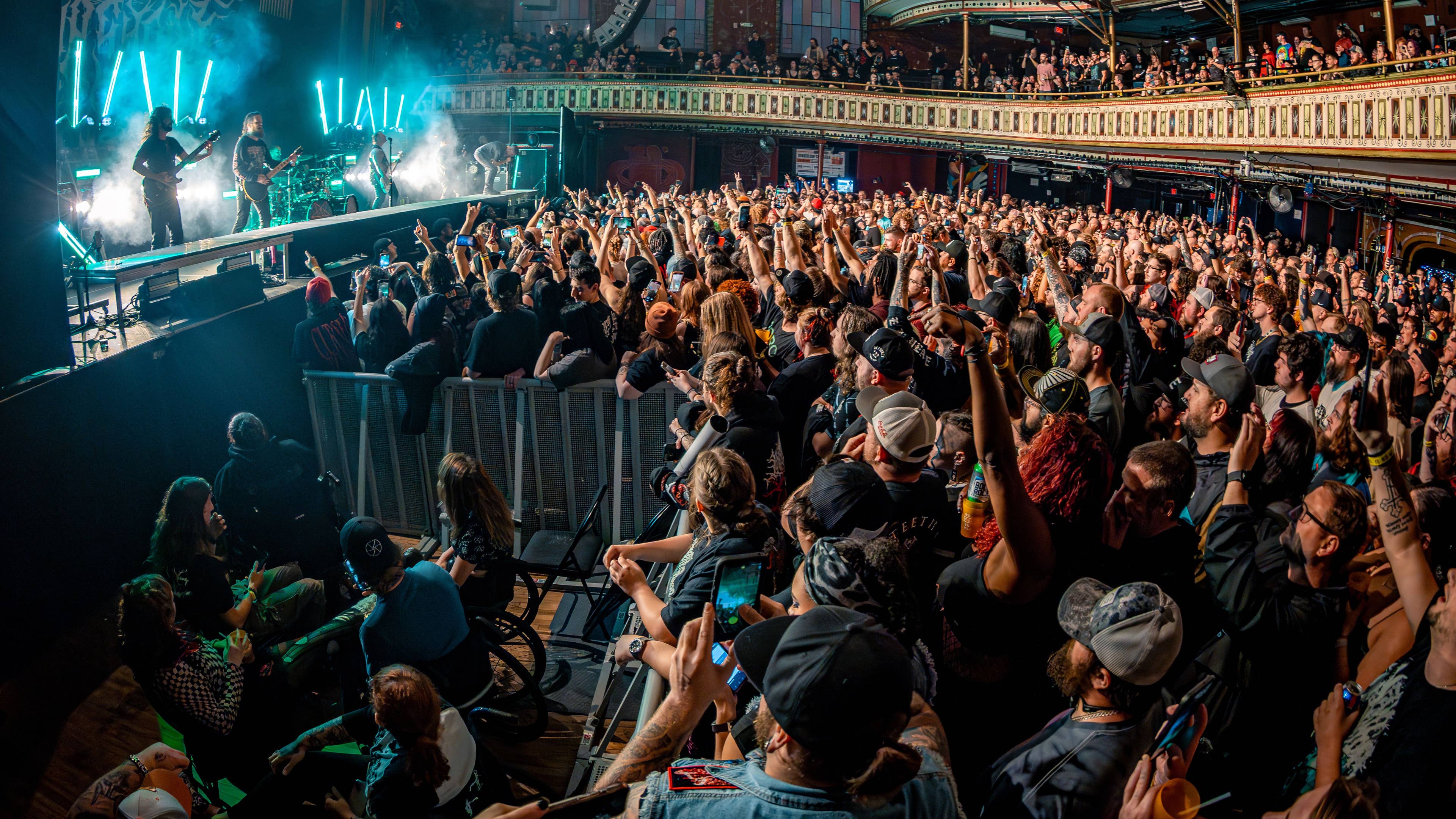 A view of the side of the stage with fans enjoying a concert