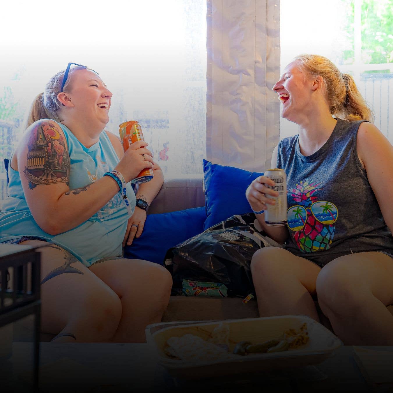 Two friends laughing and enjoying drinks in the VIP Club