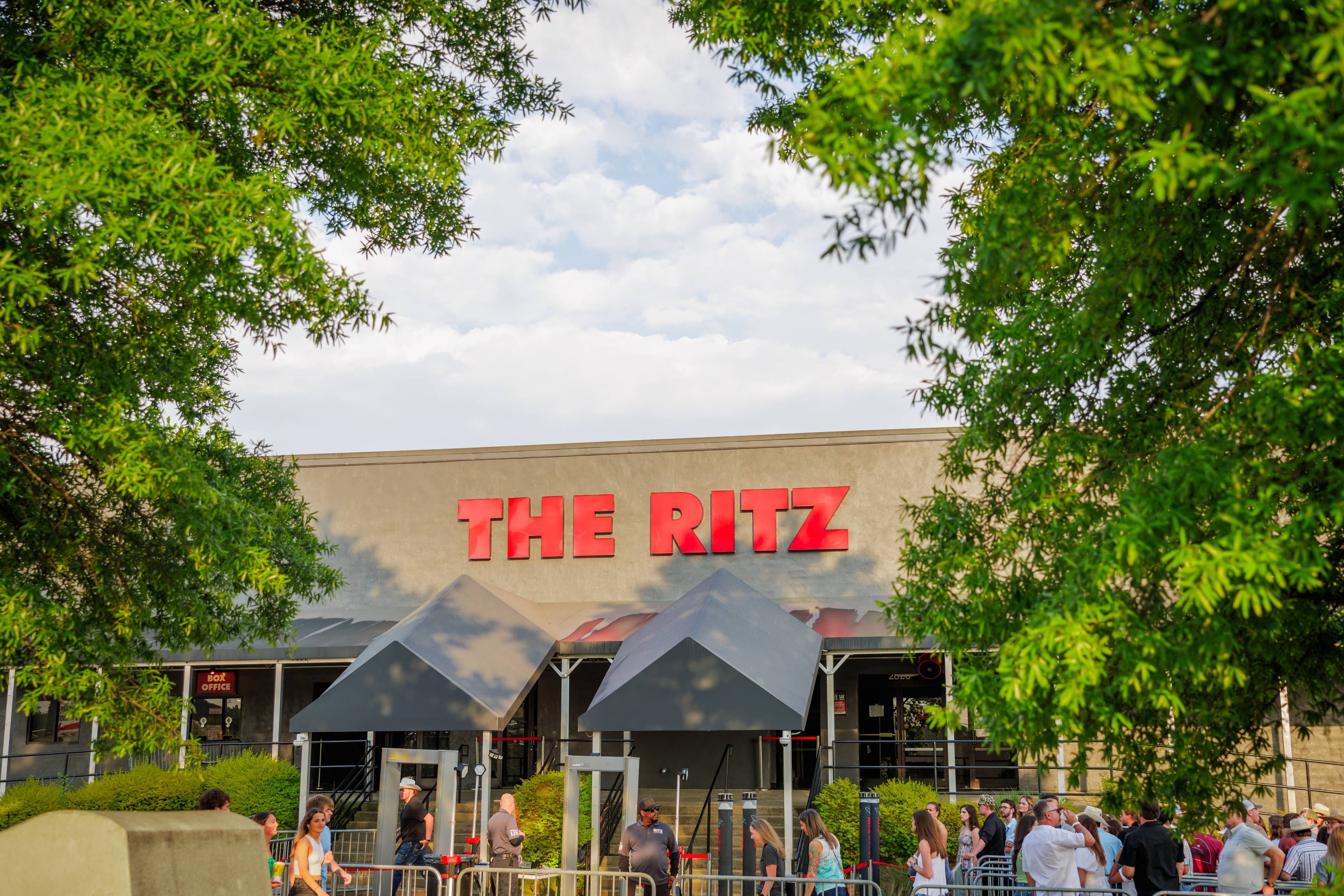 Trees and the front wall of The Ritz Raleigh concert venue with red neon The Ritz sign