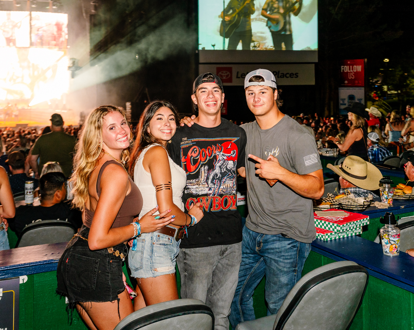 Four people standing and facing the camera at a concert