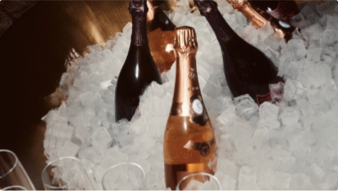 Bottles in an ice container with champagne glasses nearby