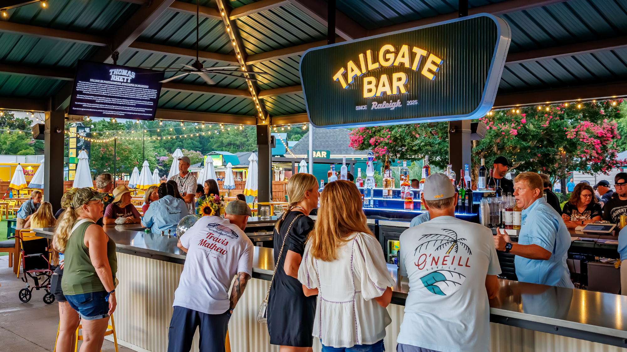People order drinks at the Tailgate Bar in the Backyard VIP Club.