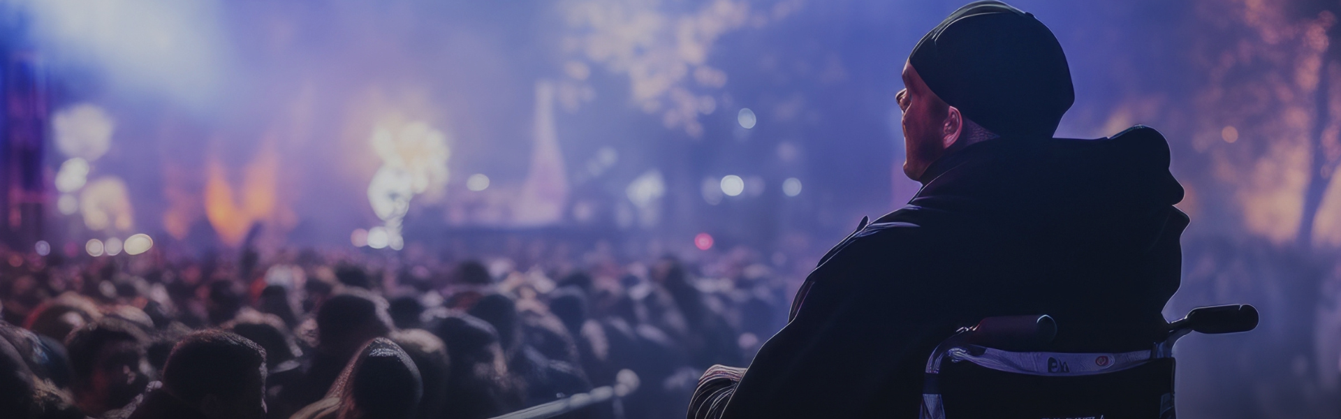 A person sitting in a wheelchair at an event facing the stage