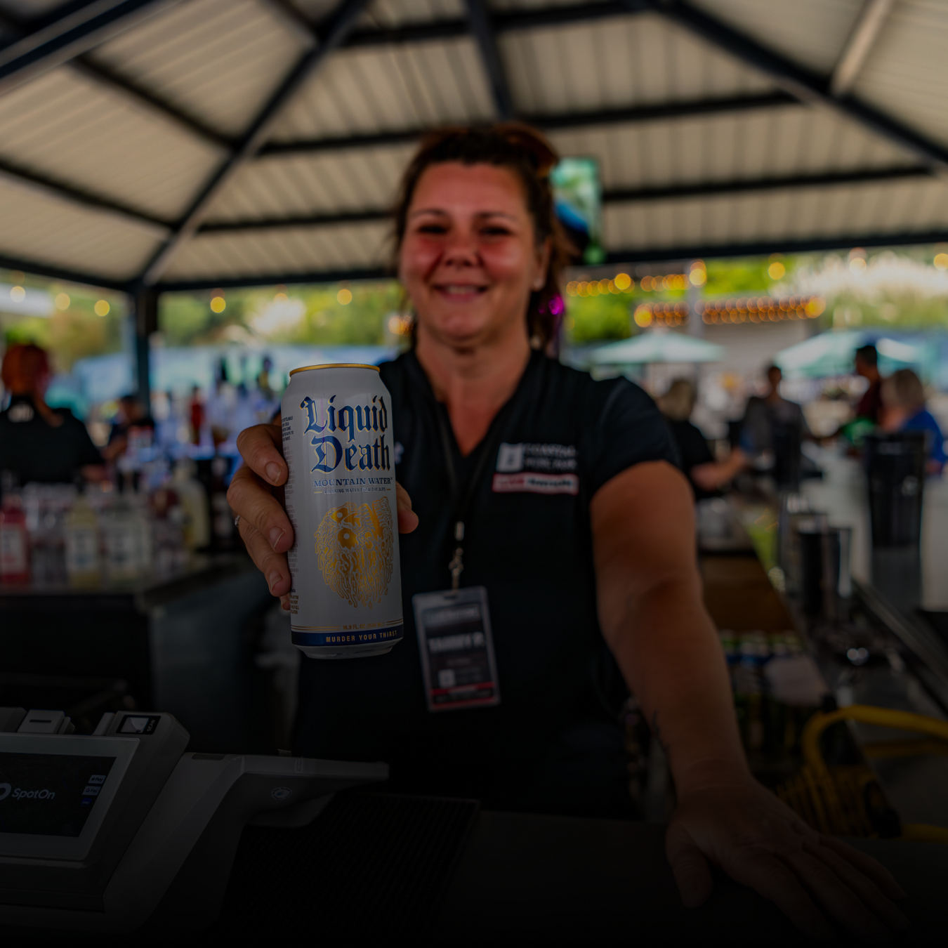 A bartender holding a can of Liquid Death water