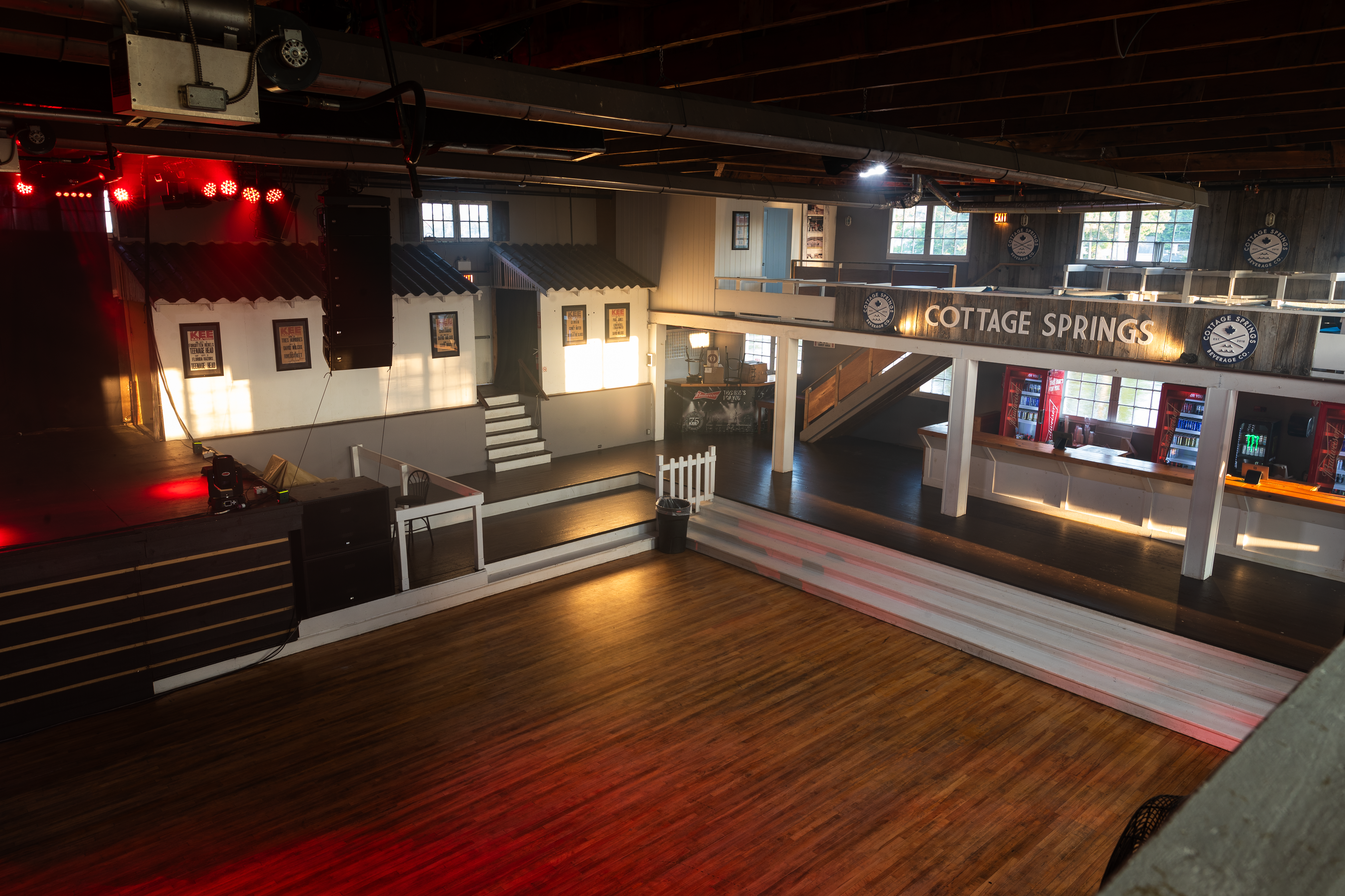 view of an empty room (main room at  the kee to bala) from the balcony with stairs visible 
