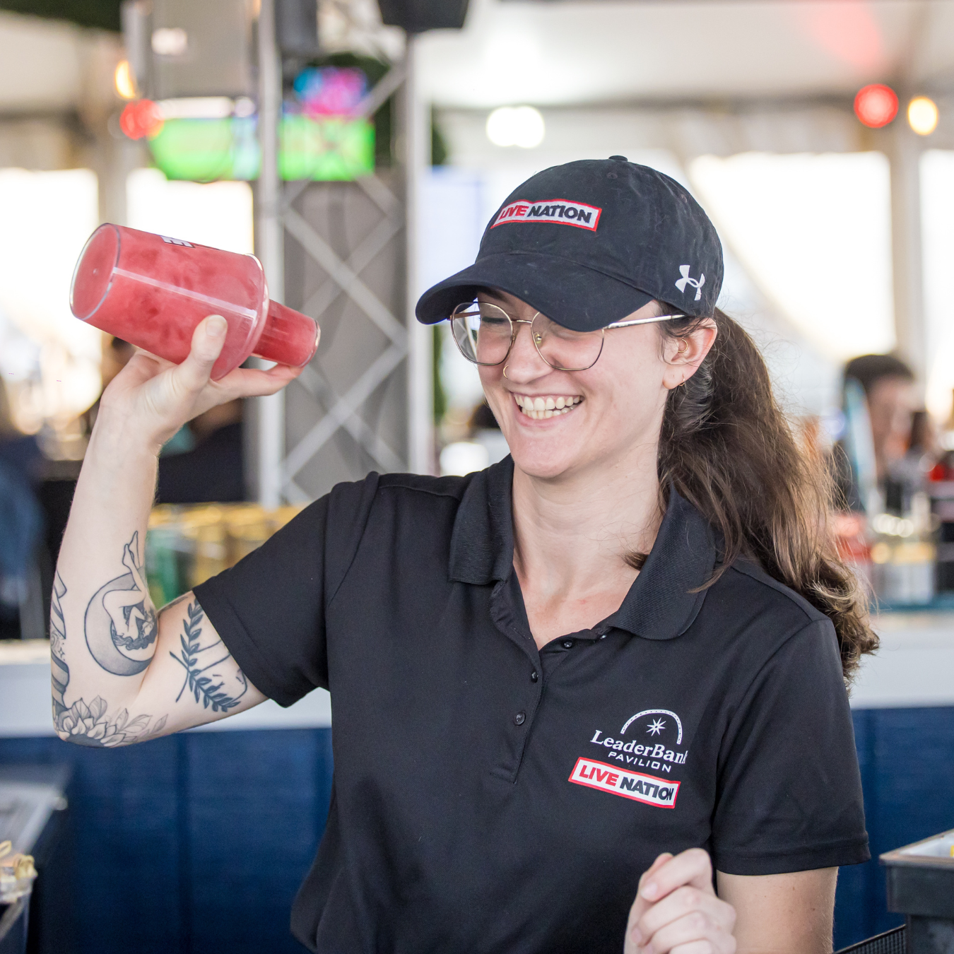 A person making a cocktail in the shaker cup