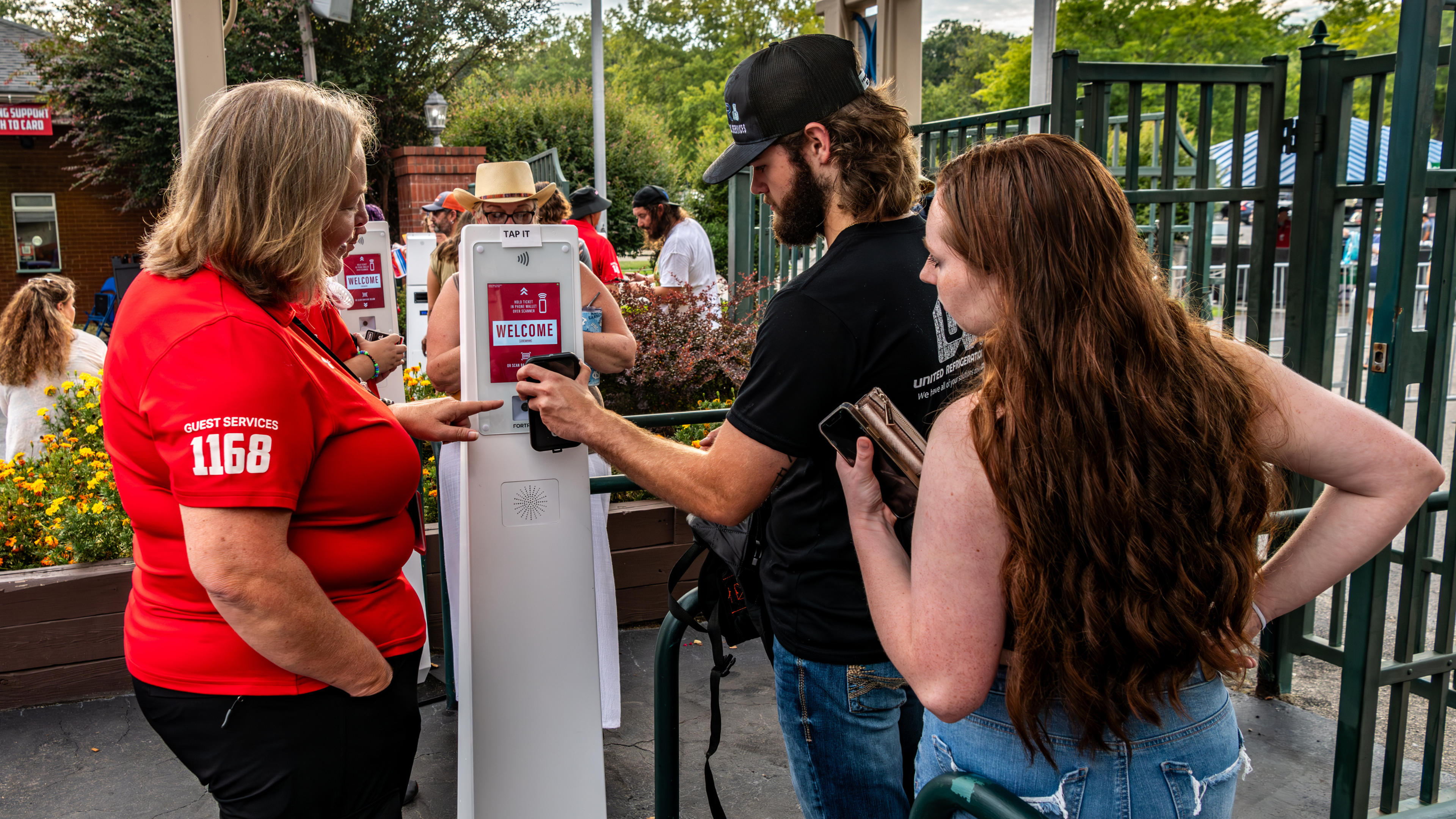 A man scans his phone concert ticket with a woman venue worker