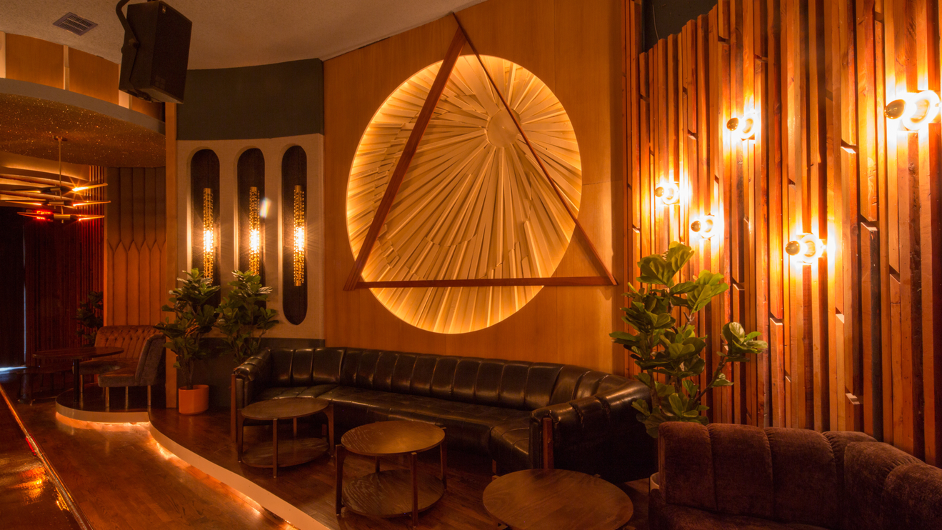 A dimly lit room with couches and tables