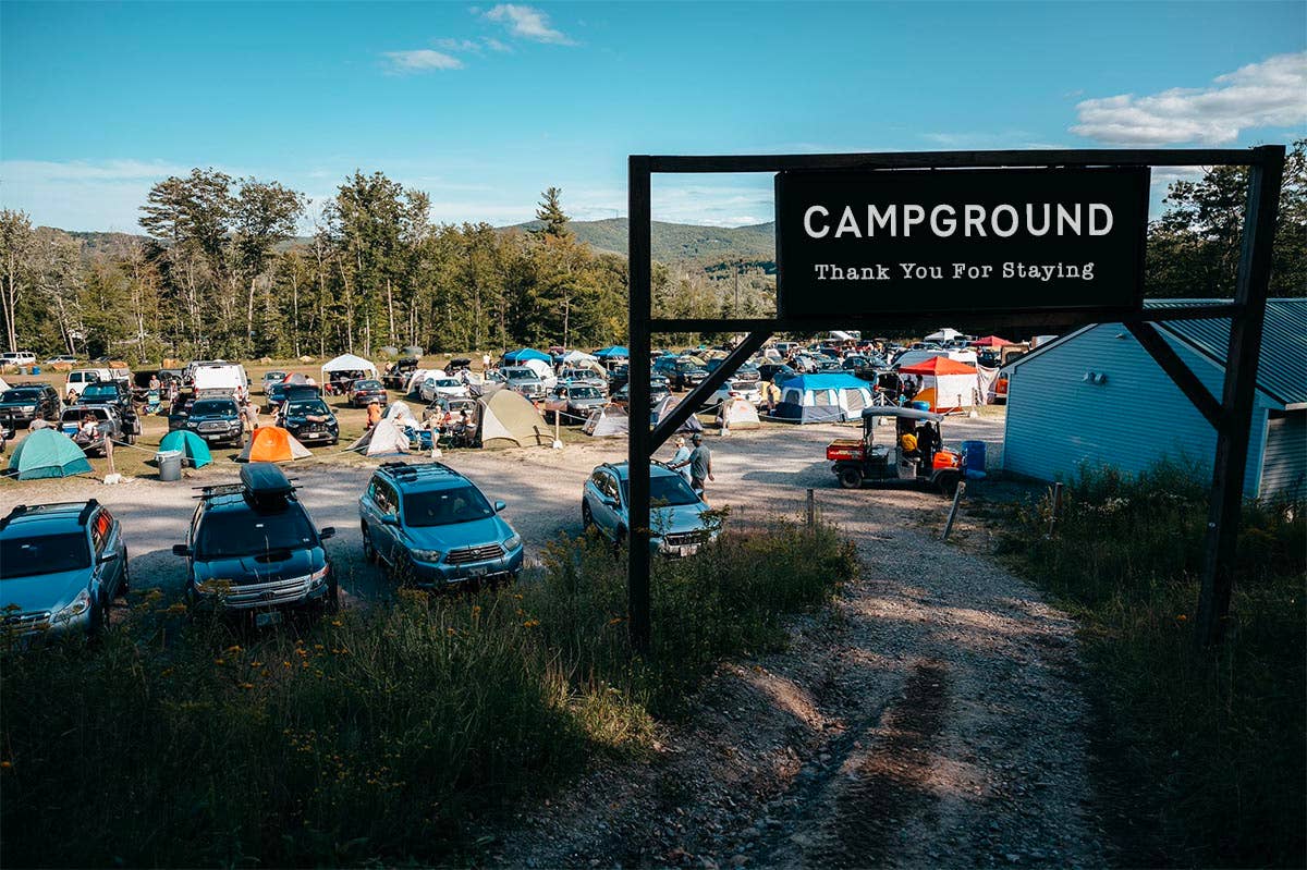 photo of cars behind the campground sign 