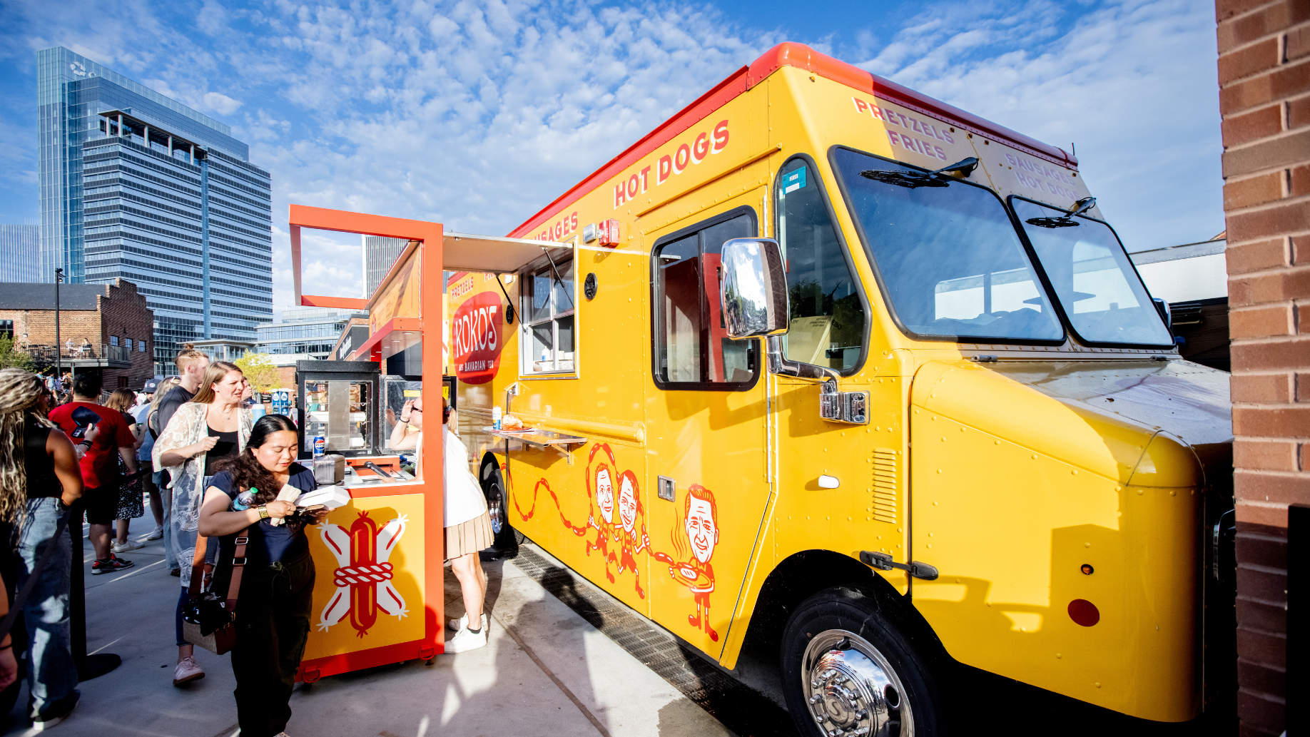 Large yellow food truck serving hot dogs and fries parked inside the venue.