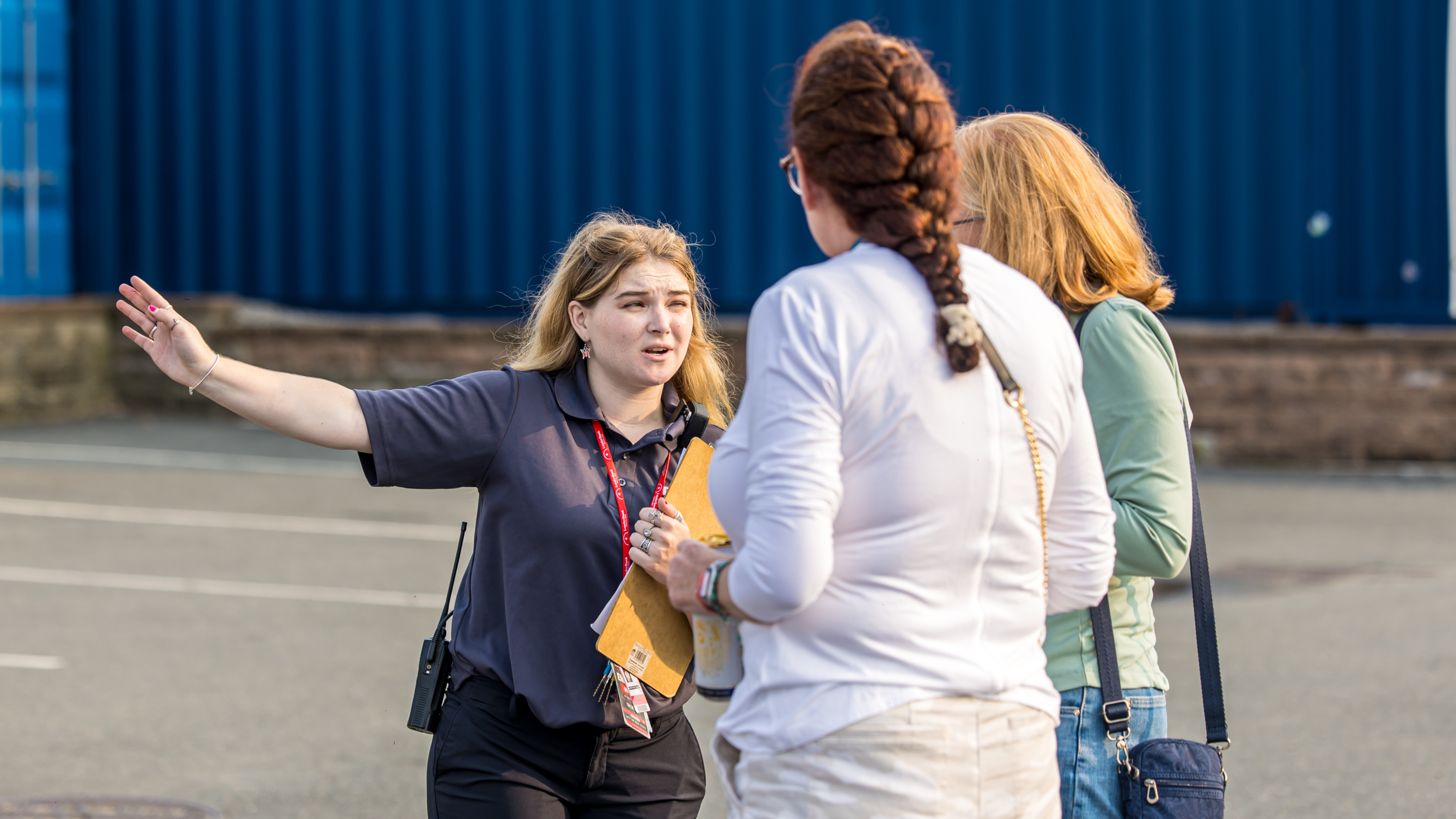 A guest services person instructing people to enter