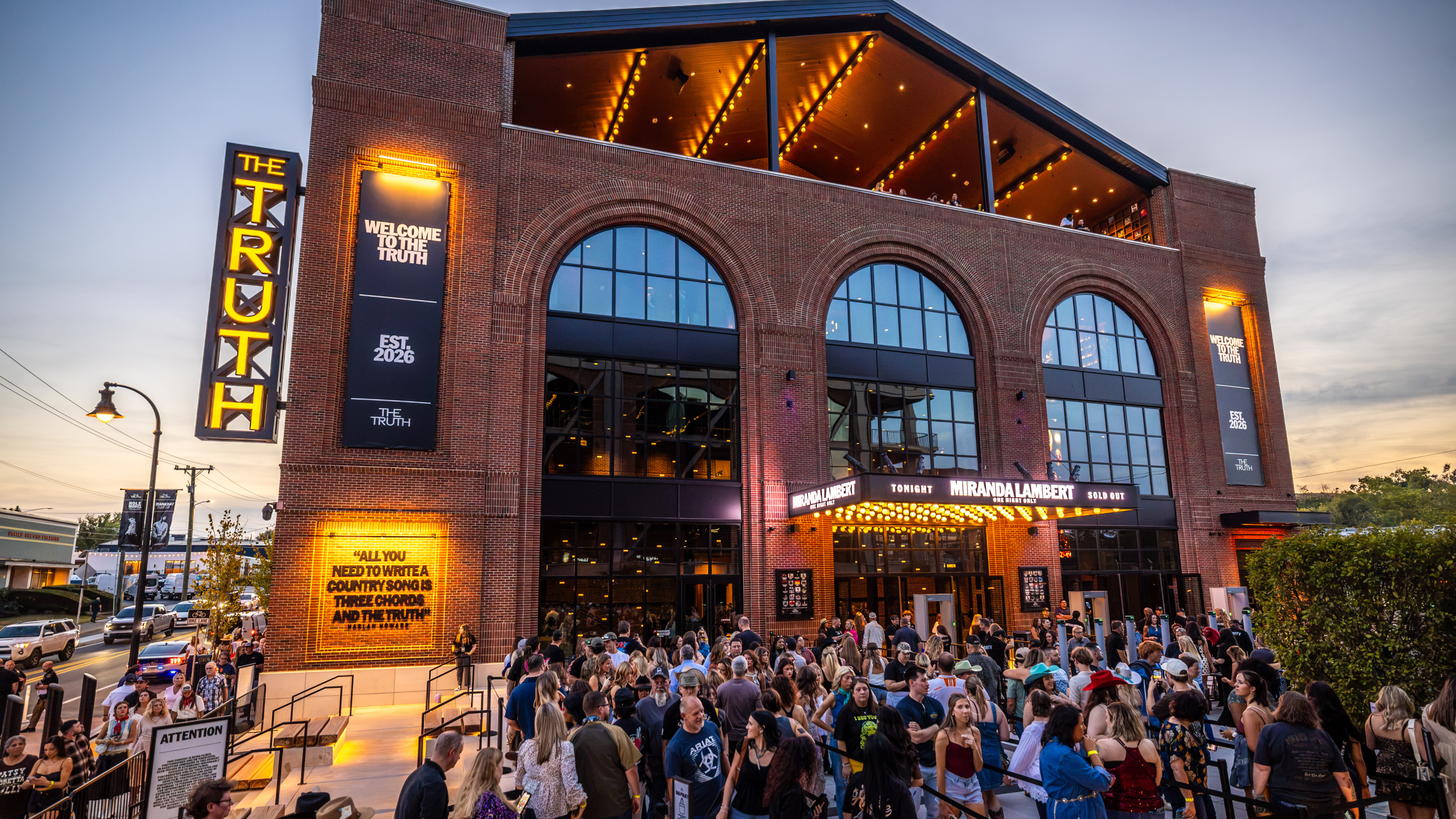 The Truth’s brick exterior at dusk, with its illuminated marquee, upper-level terrace, and guests arriving for a sold-out Miranda Lambert show. Photo credit: Alive Coverage