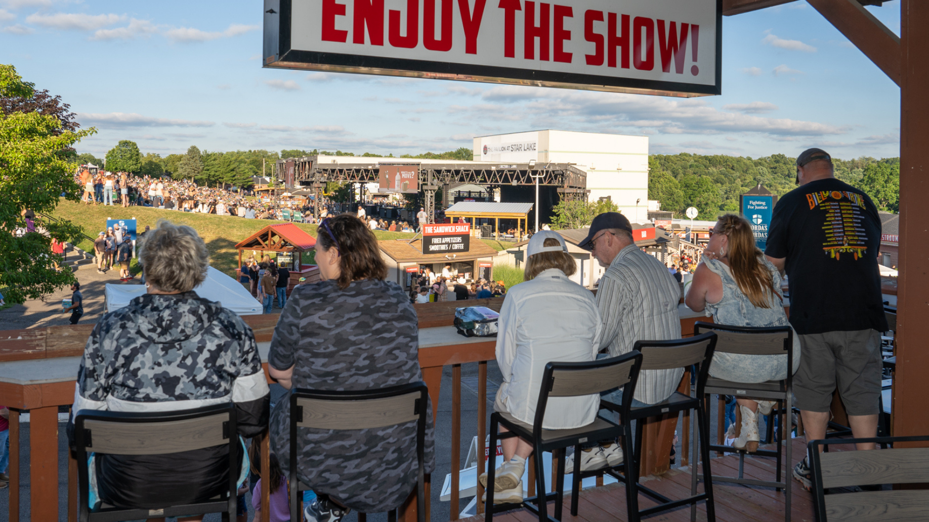 Fans sitting inside The Cabana and looking out towards a partial view of the stage. 