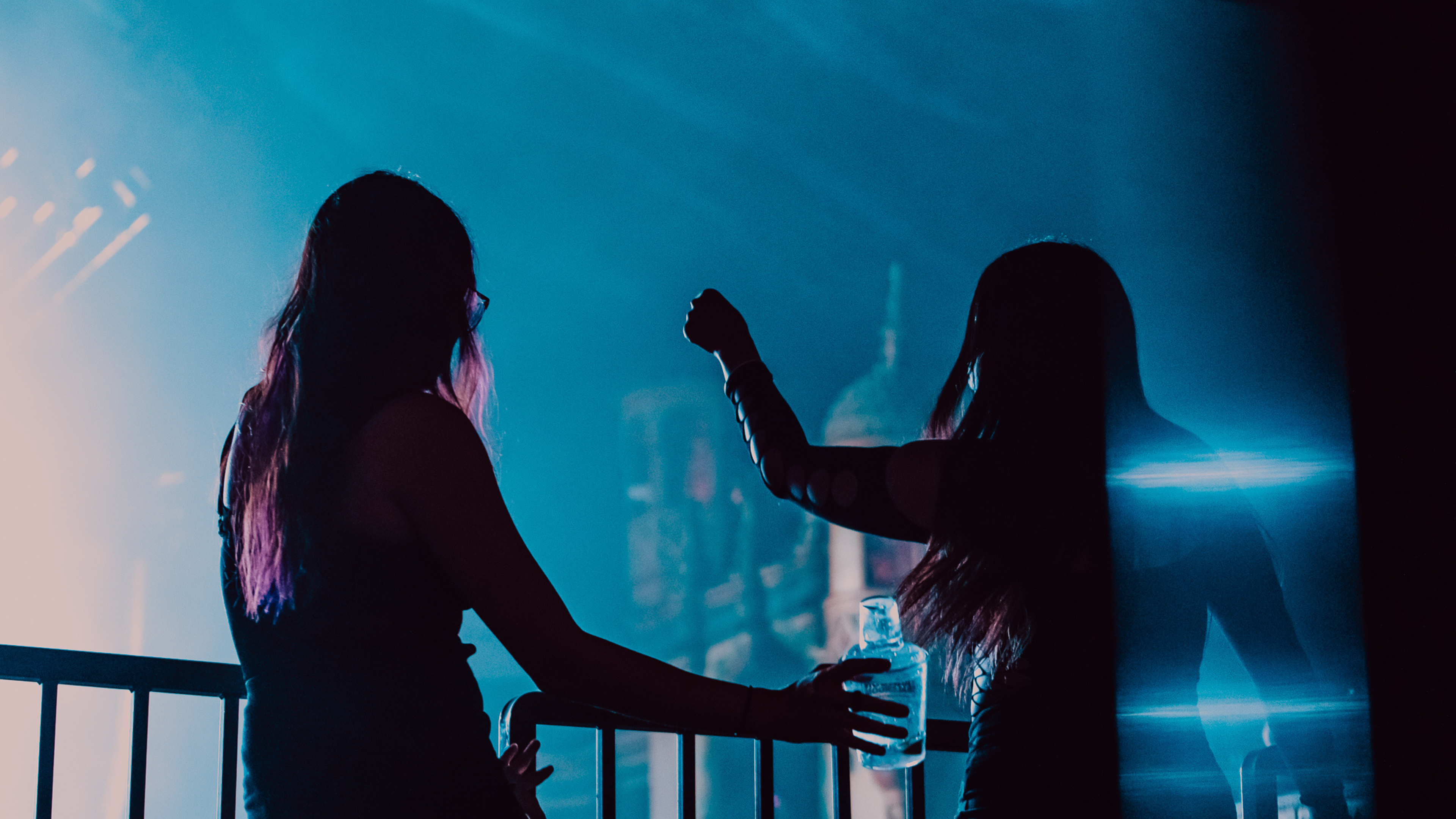 Two women dance at a concert.