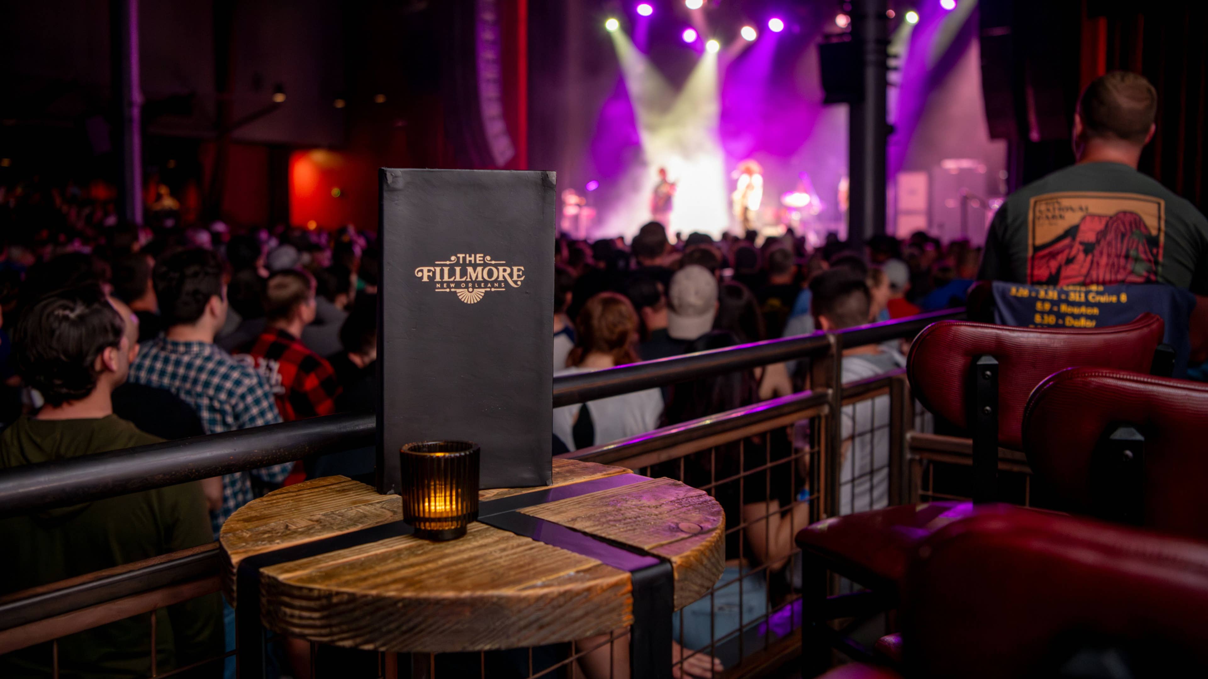A VIP menu placed on a box seat overlooking a crowd of fans and the stage