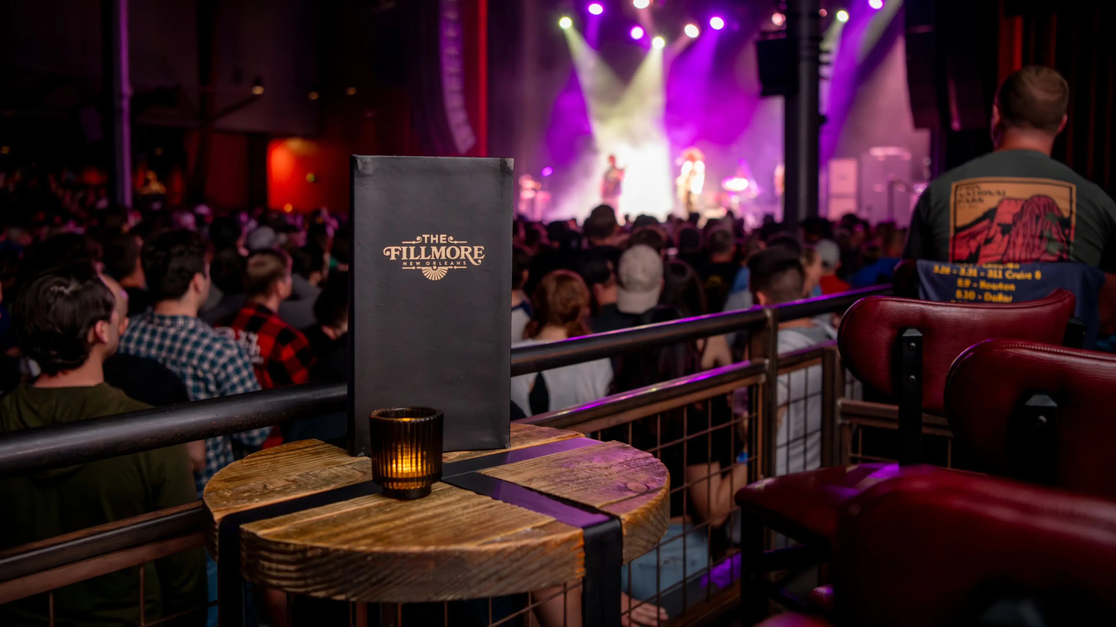 A VIP menu placed on a box seat overlooking a crowd of fans and the stage