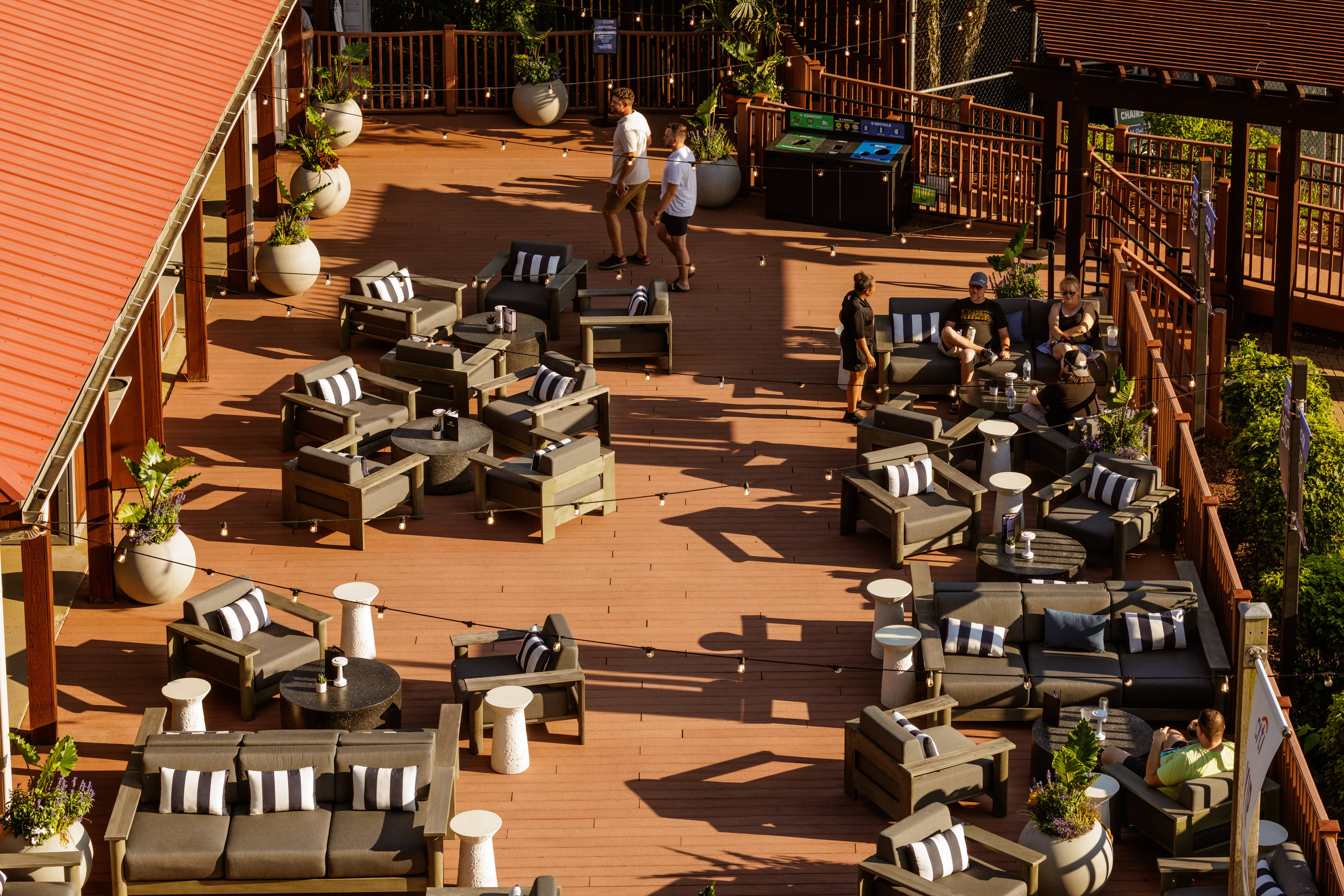 Overview of the VIP club area showing all the couches and chairs available. People are sitting down and there are two men walking around.