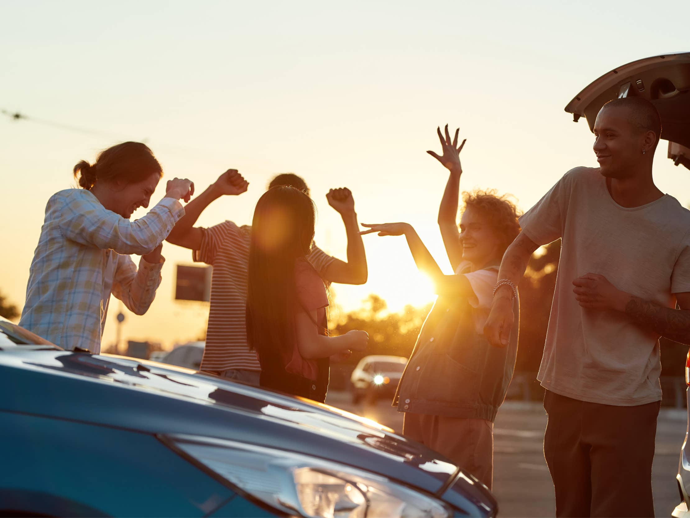 A group of people dancing in the parking lot