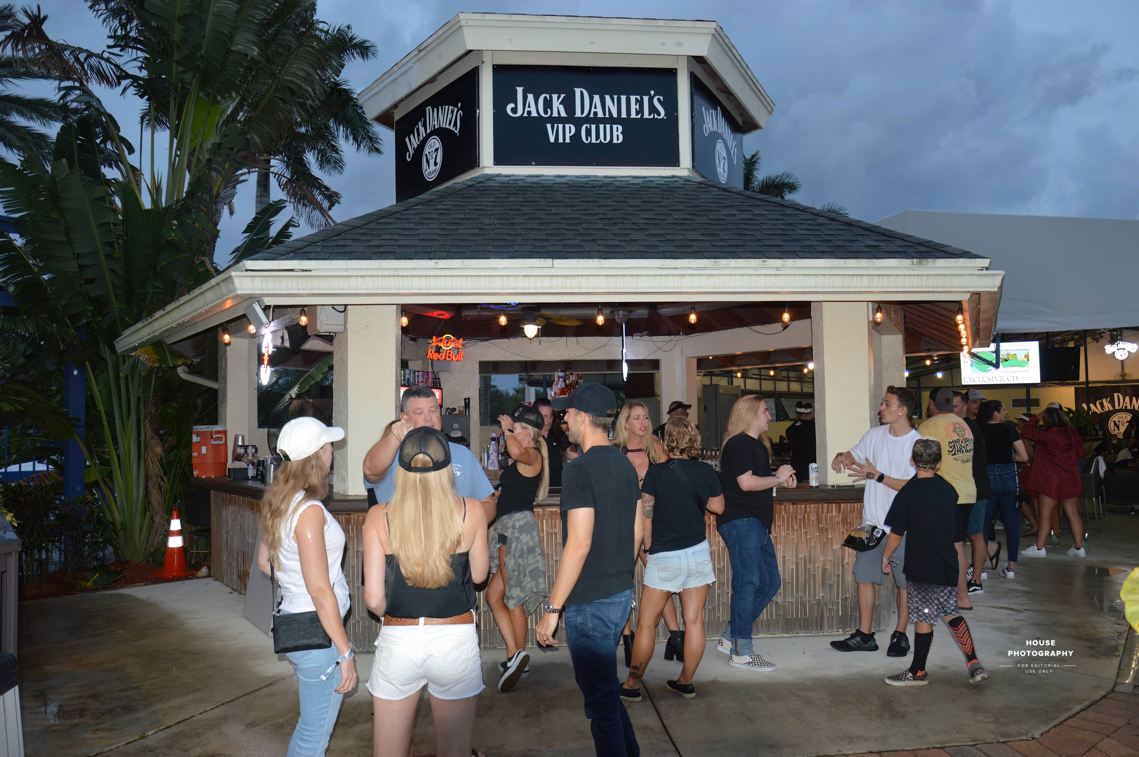 People outside talking next to a bar.