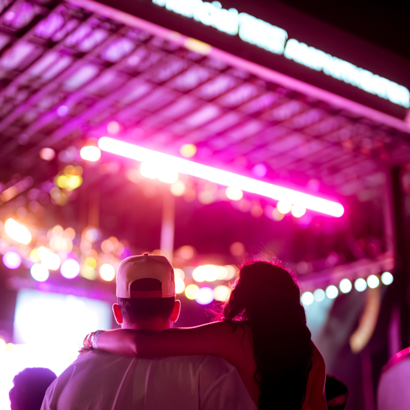 A couple watches the stage with their arms around each other