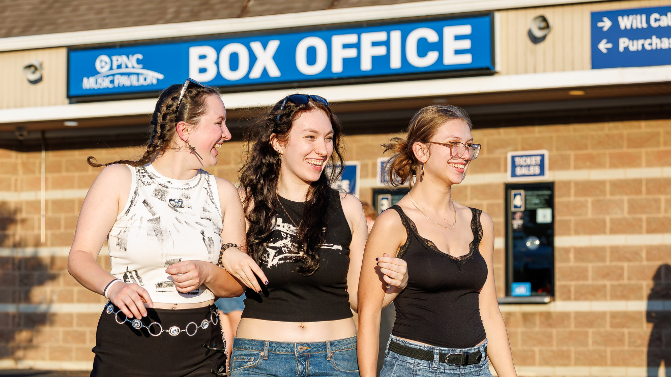 Three girls walking in front of the Box Office at PNC Music Pavilion.