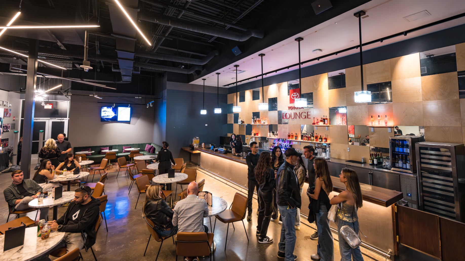 The VIP Club showing fans sitting and chatting at tables, while other fans stand around a private bar.