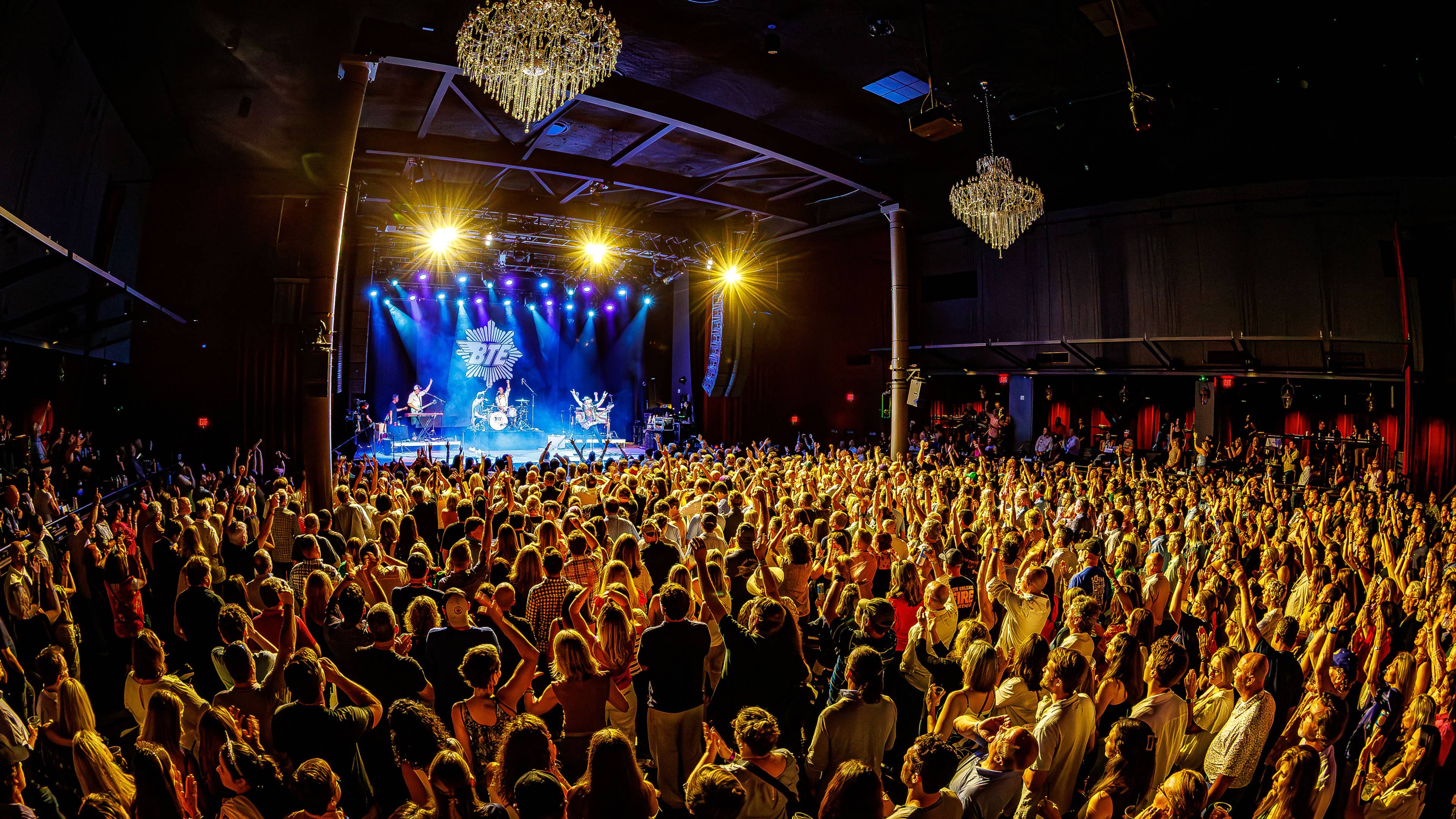 A crowd of fans cheering and watching a concert