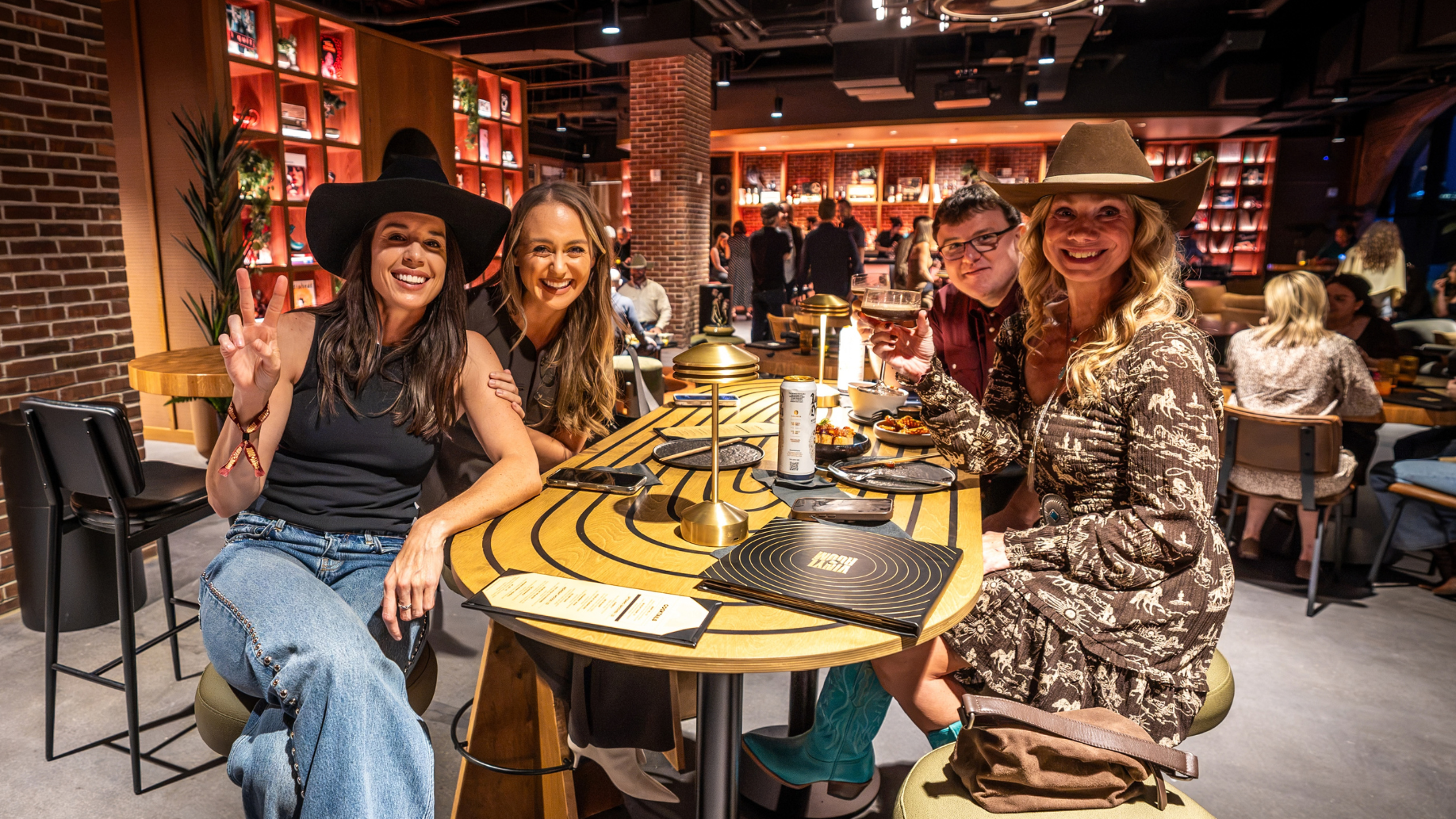 Fans sitting around a table eating and drinking in The Truth Vinyl Room