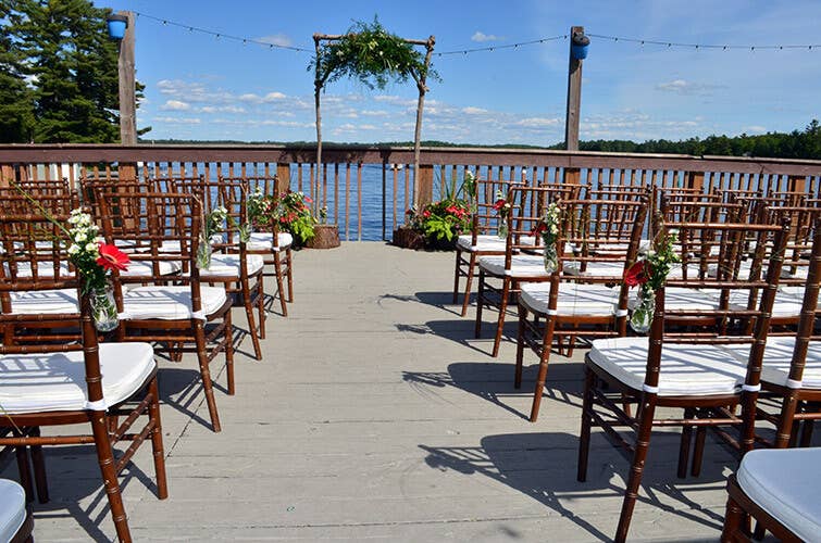 view of chairs set up for aa wedding on a balcony with the lake in the back