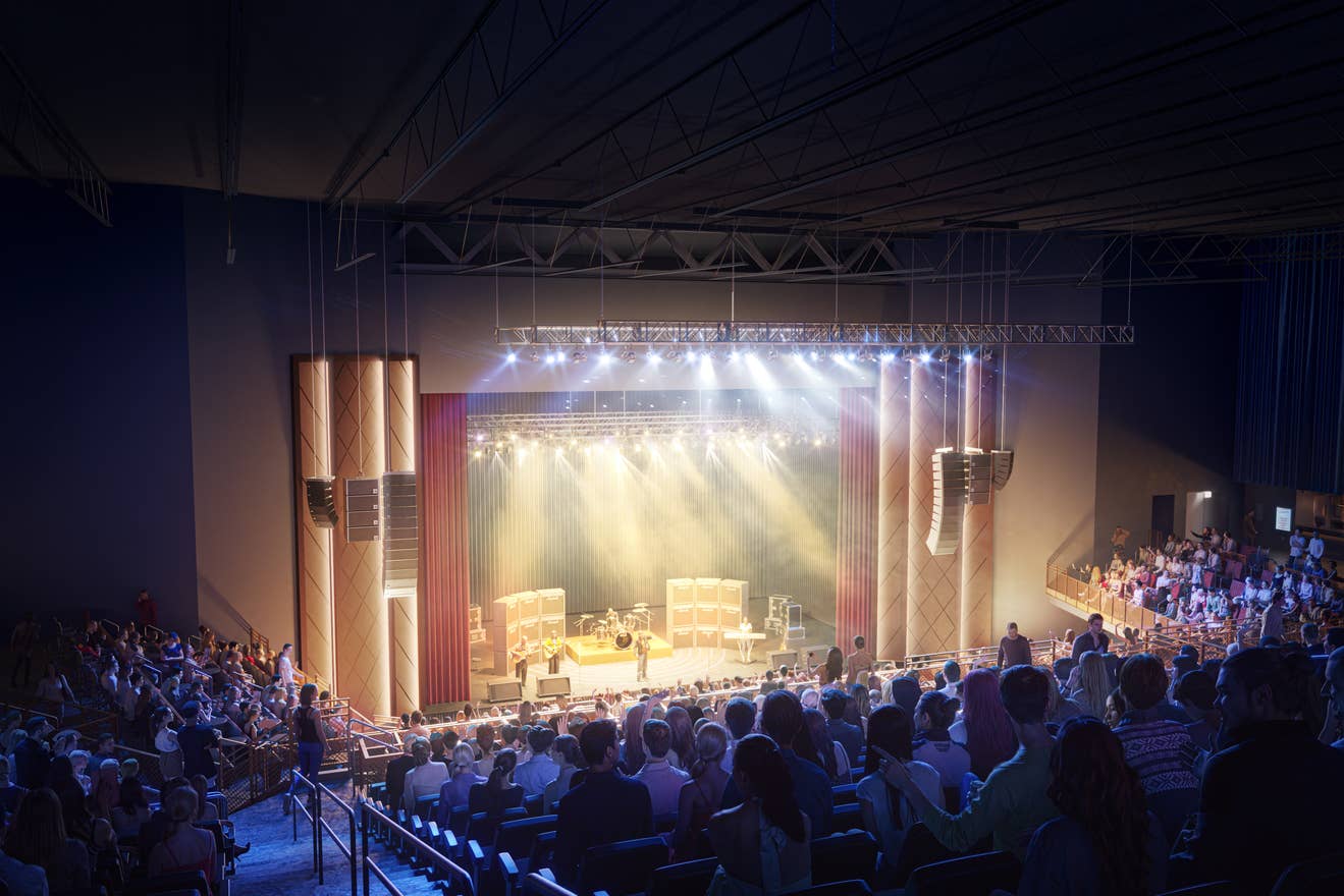 A view of an audience members sitting on the left side of the seating area facing the stage