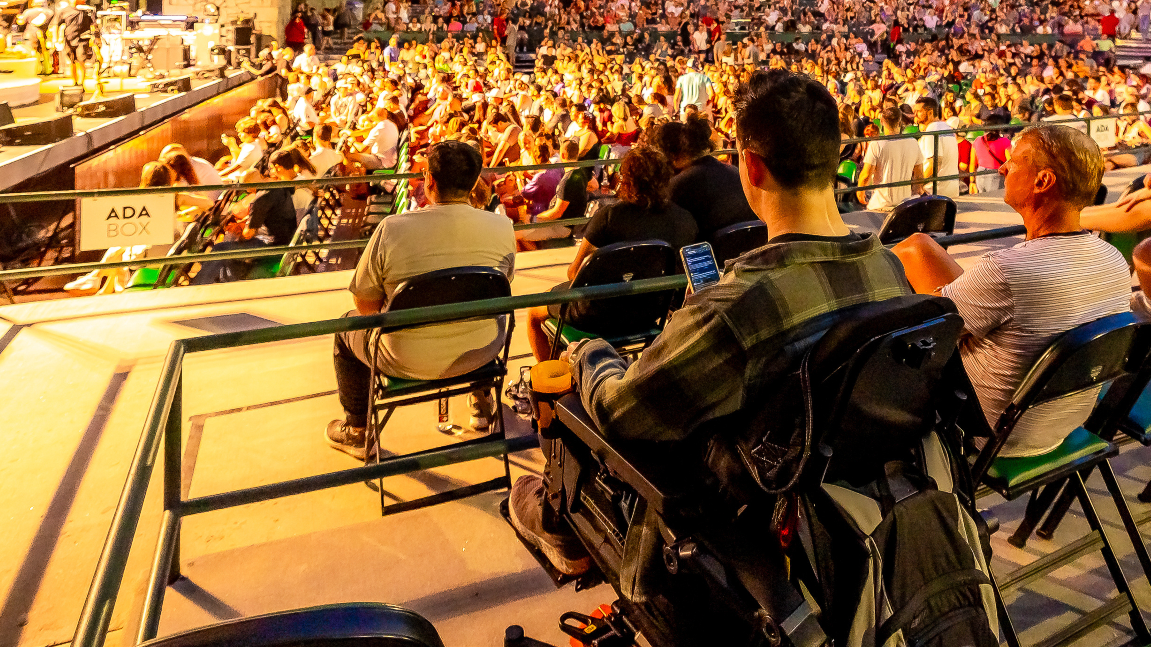 A man in a wheelchair watches a concert