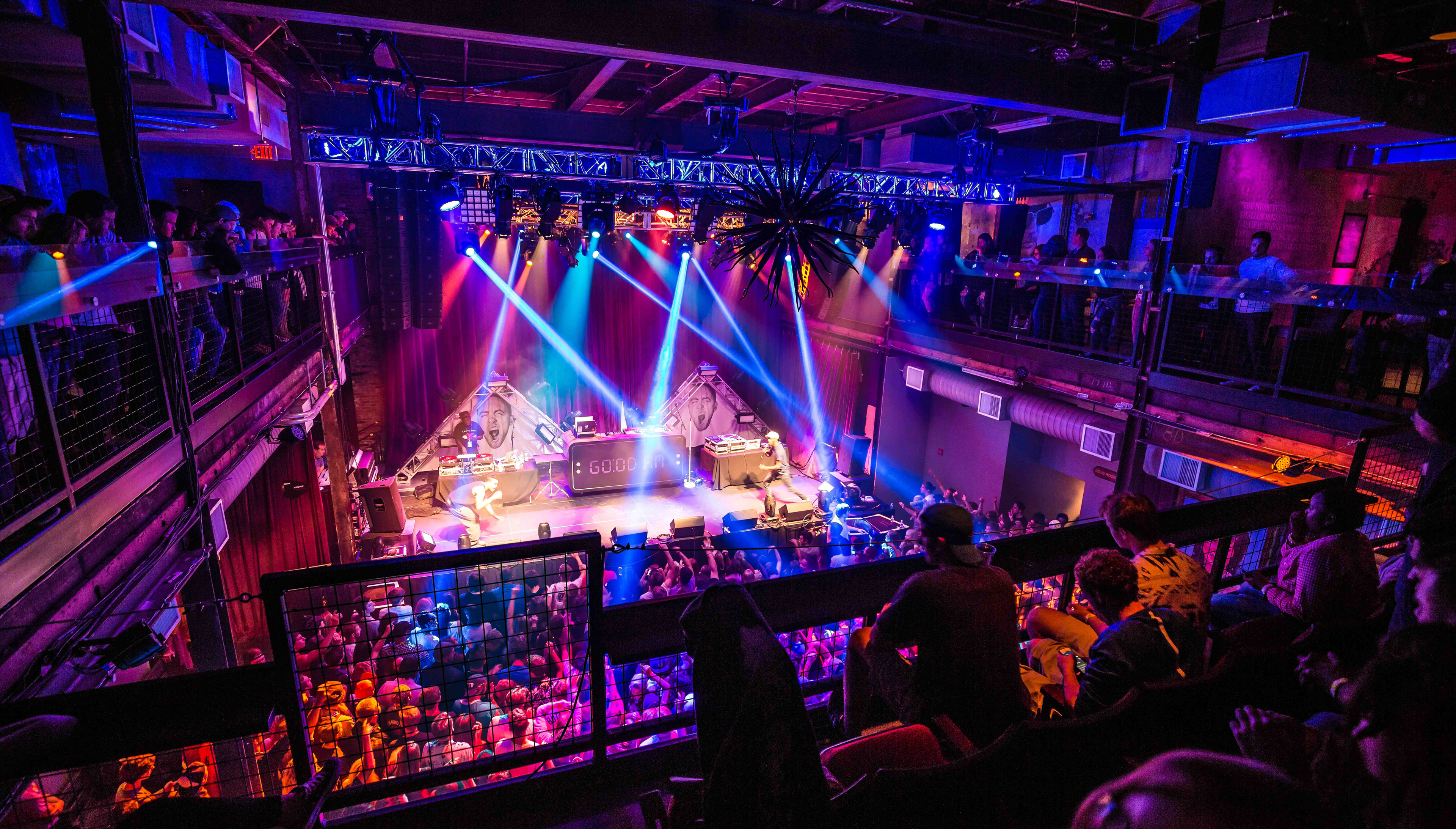 A DJ set lights up the stage as a packed crowd and balcony viewers enjoy the show at the Mercury Ballroom