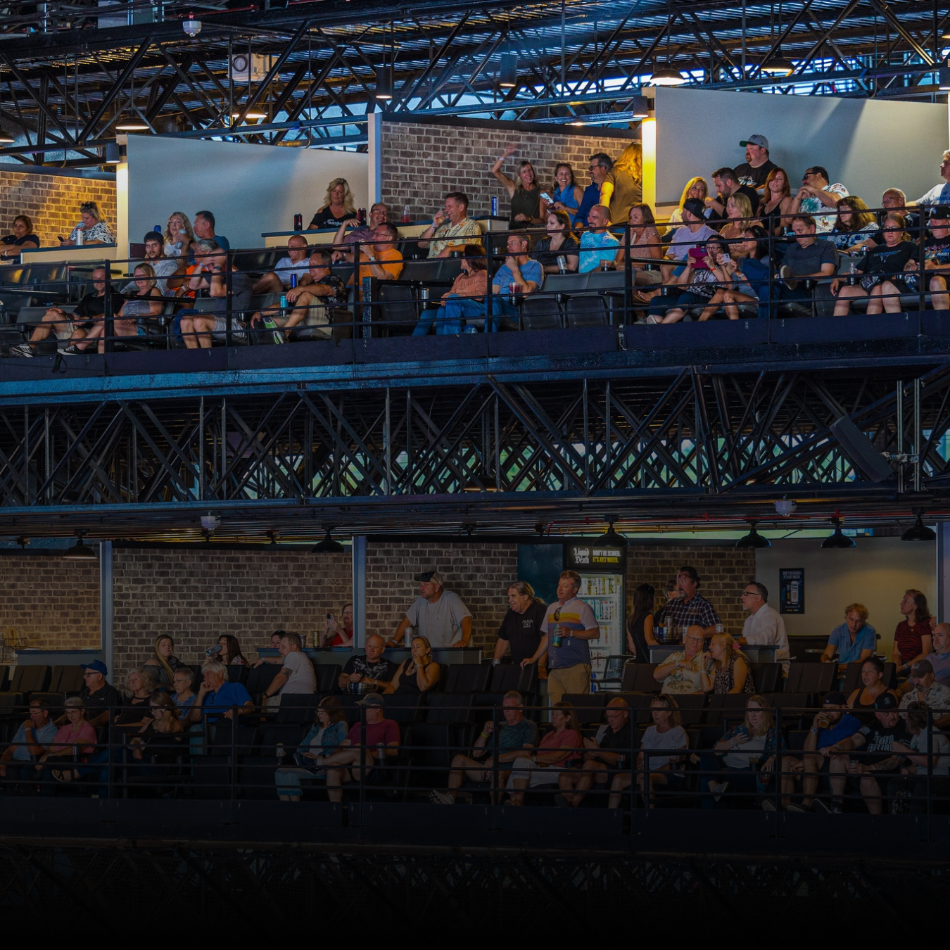 A group of people sitting in the VIP section of the audience enjoying a concert. 