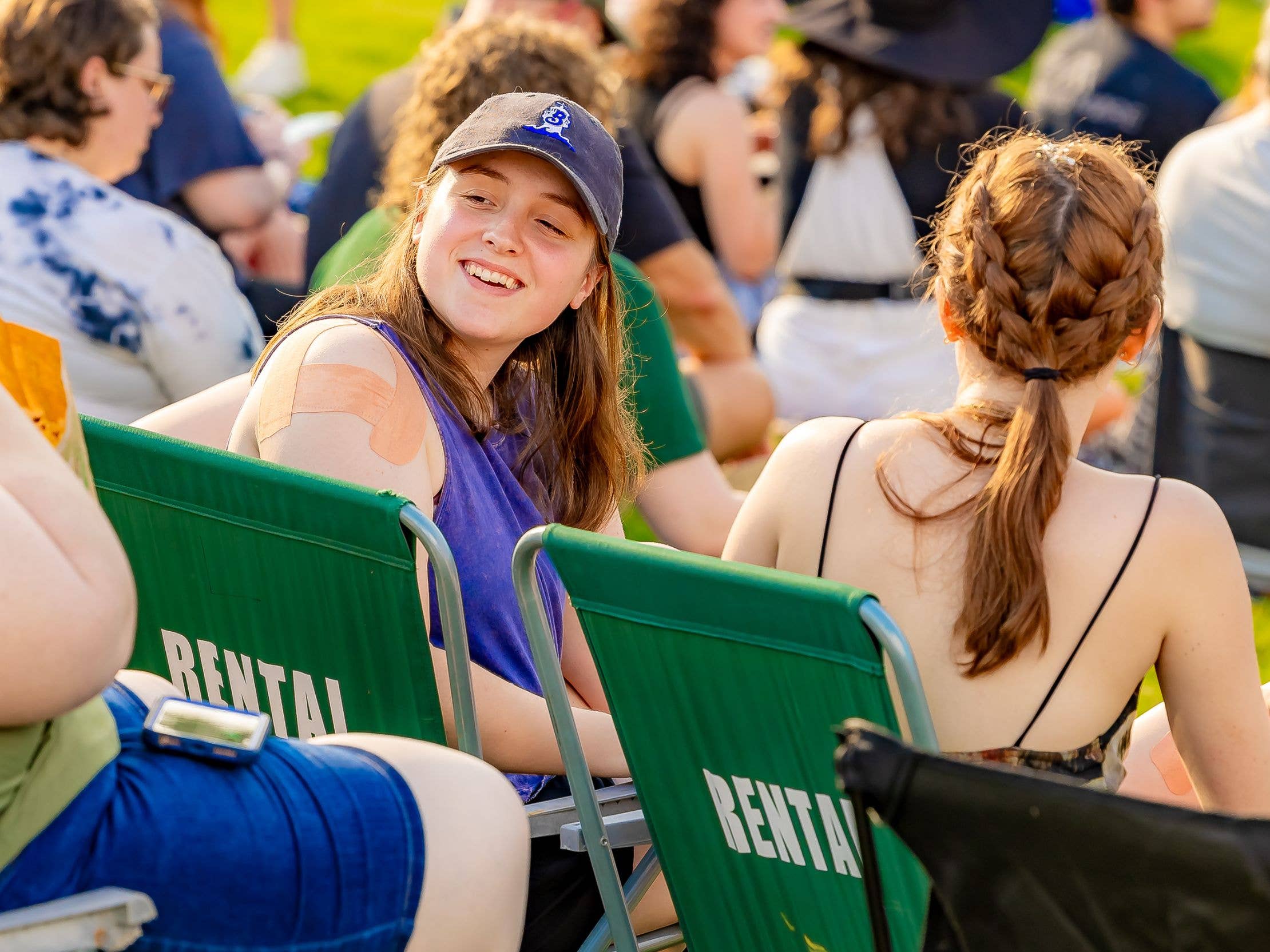 Two fans sitting in rental chairs on the lawn