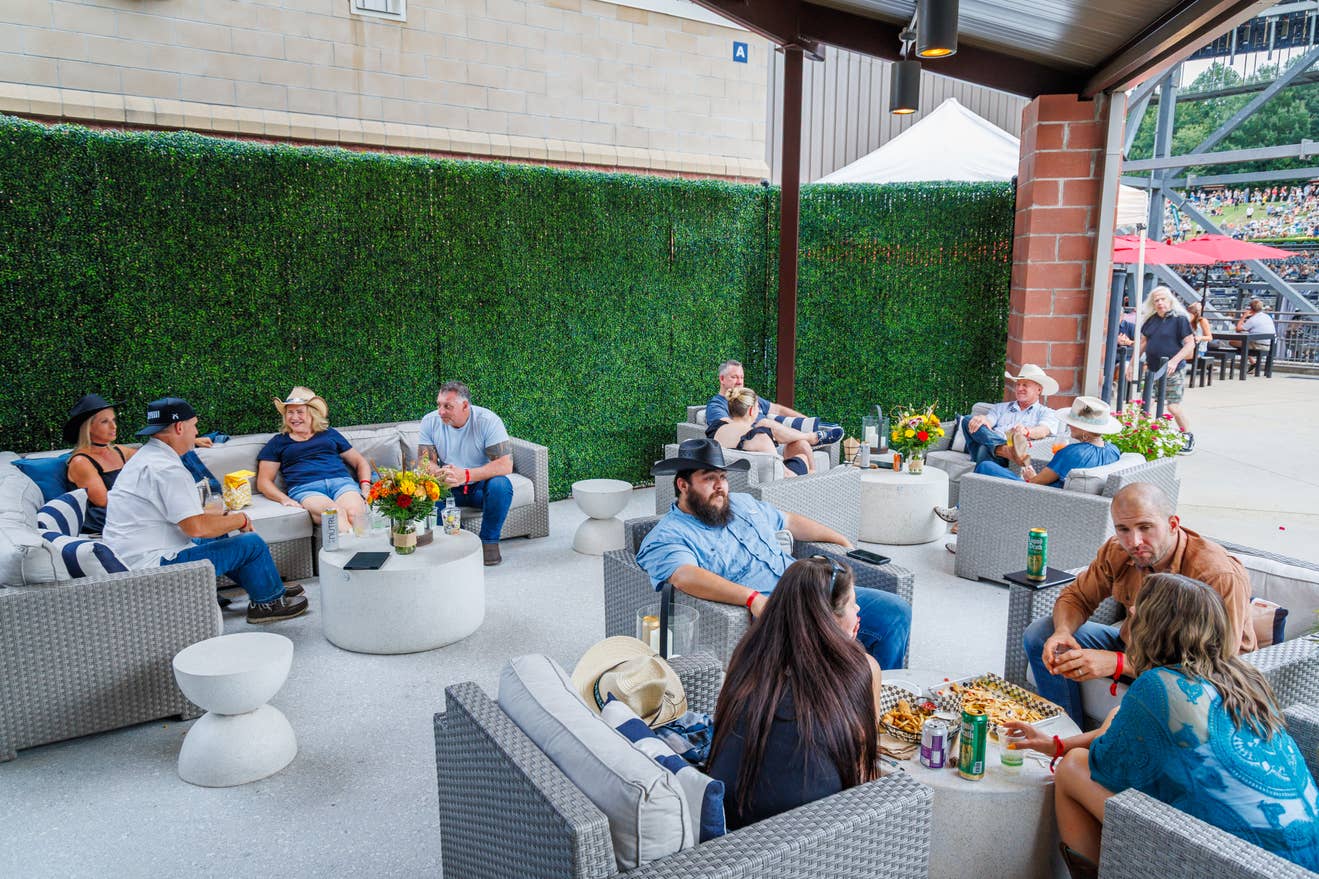 Fans sitting in lounge chairs and couches in a covered area