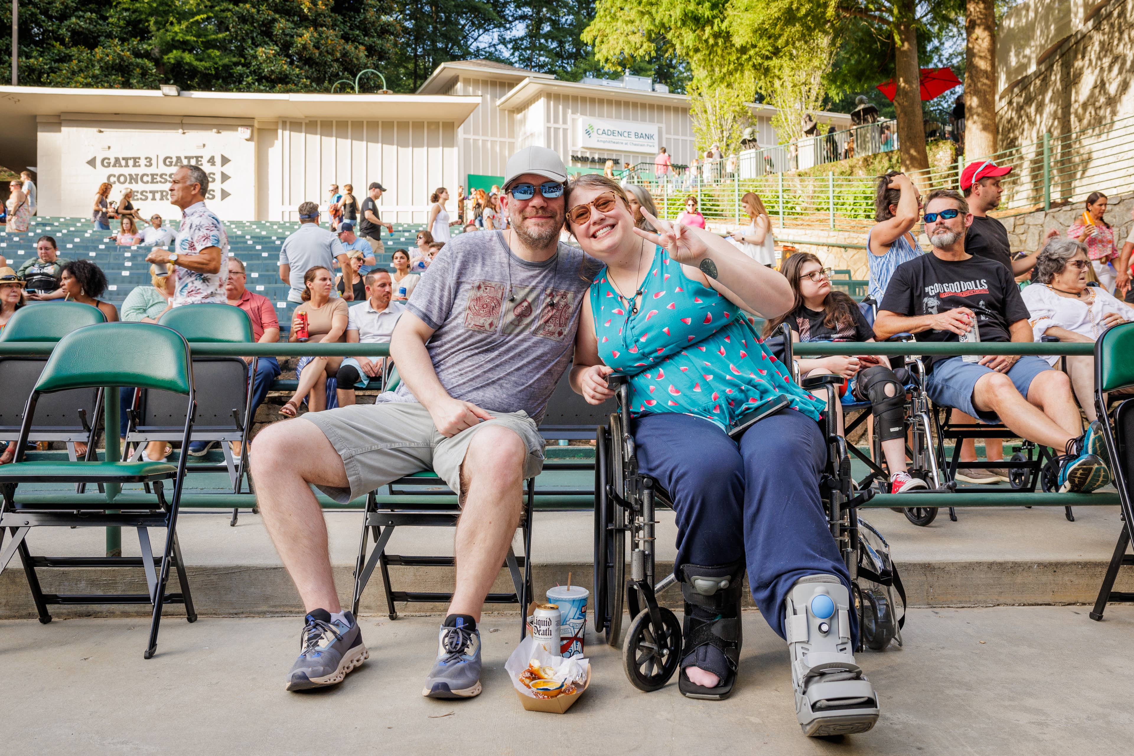 A couple, sitting along a row of removable seating.