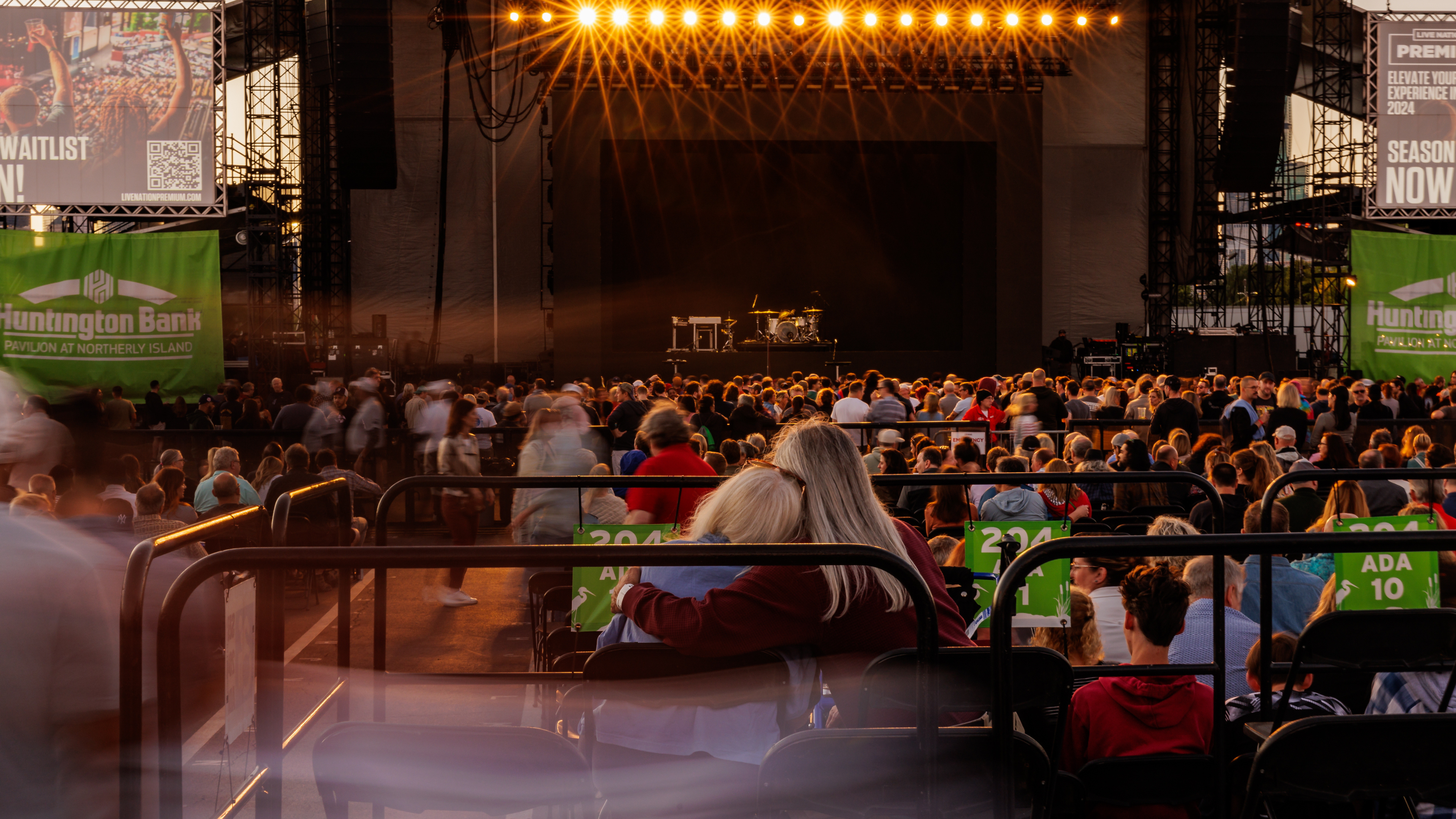 Two fans enjoy the show together from an elevated accessible viewing platform.