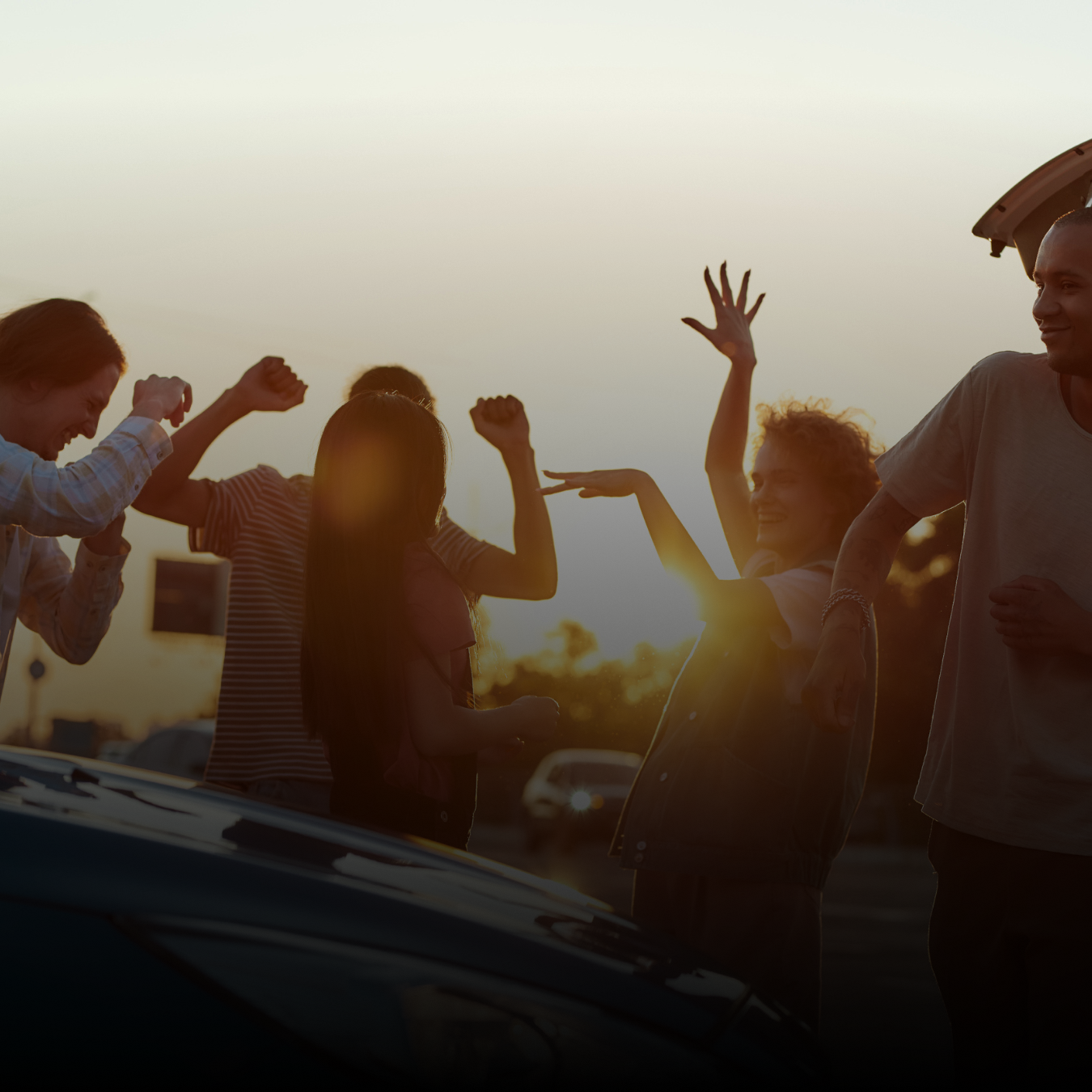 People dancing around in the sunlight in the parking lot