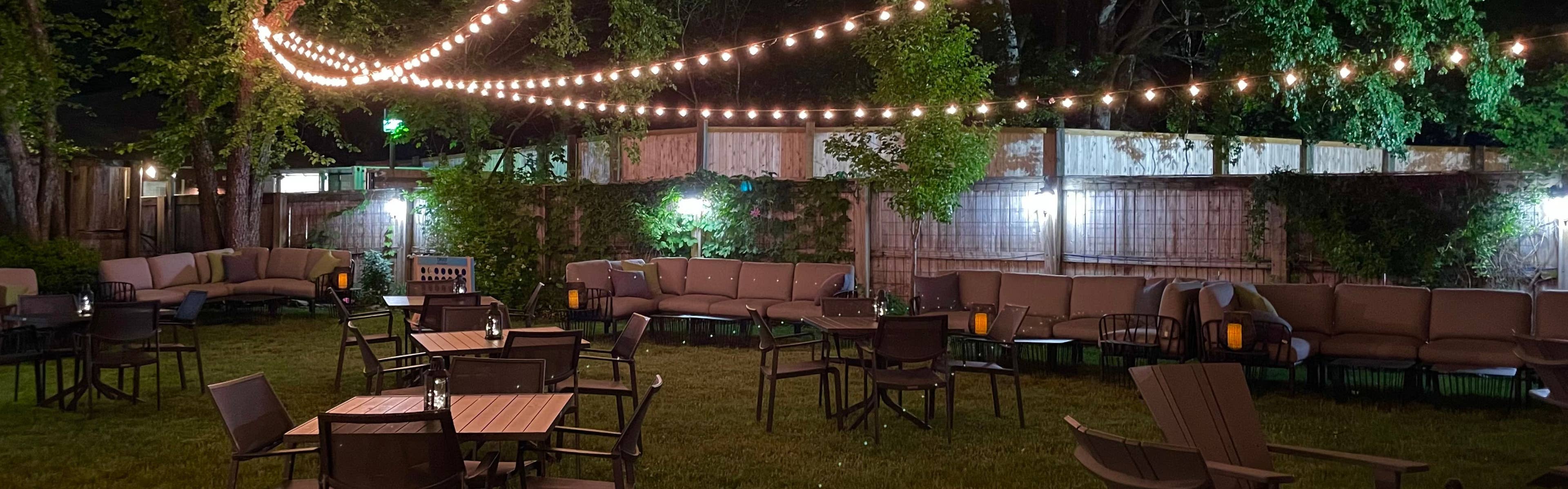 a photo of the VIP club at night with globe lights hanging over luxury seating