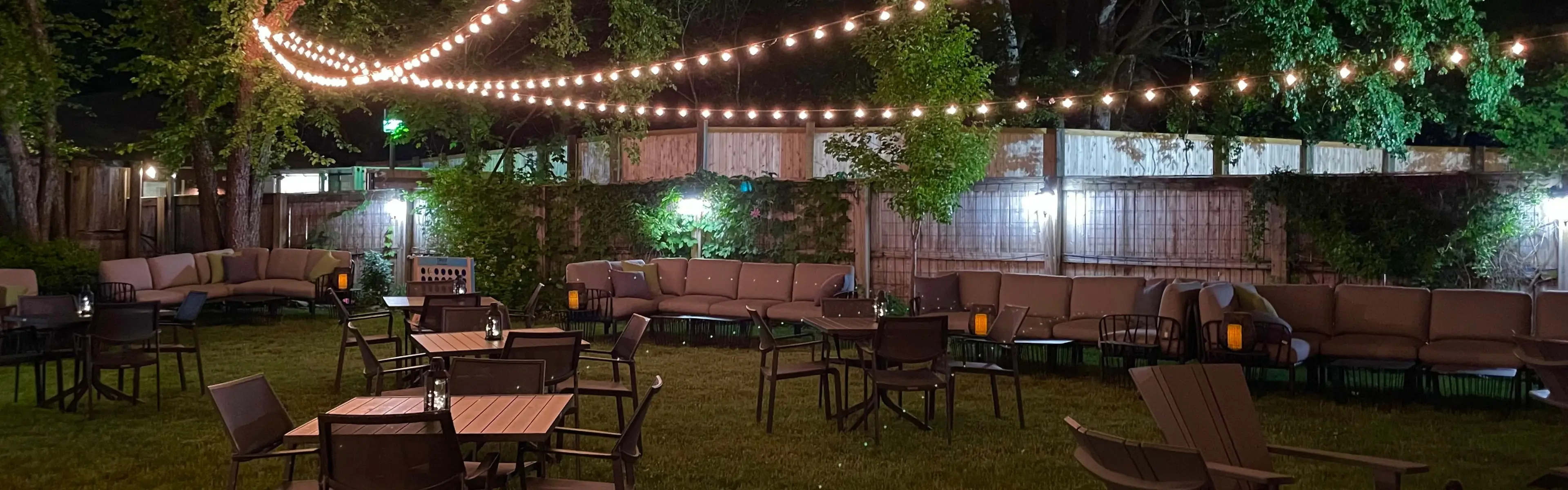 a photo of the VIP club at night with globe lights hanging over luxury seating