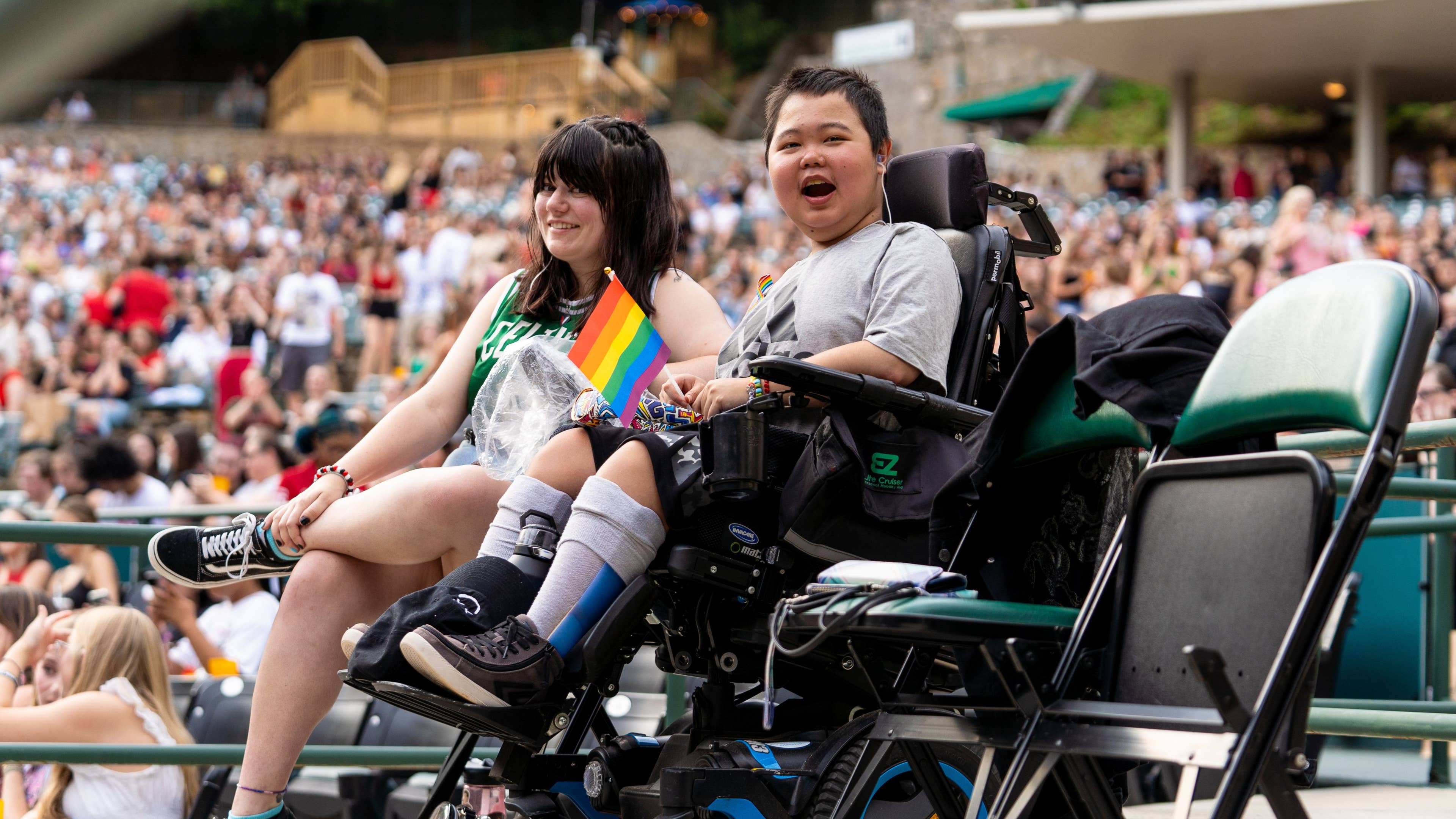 A child in a wheelchair is smiling at an event
