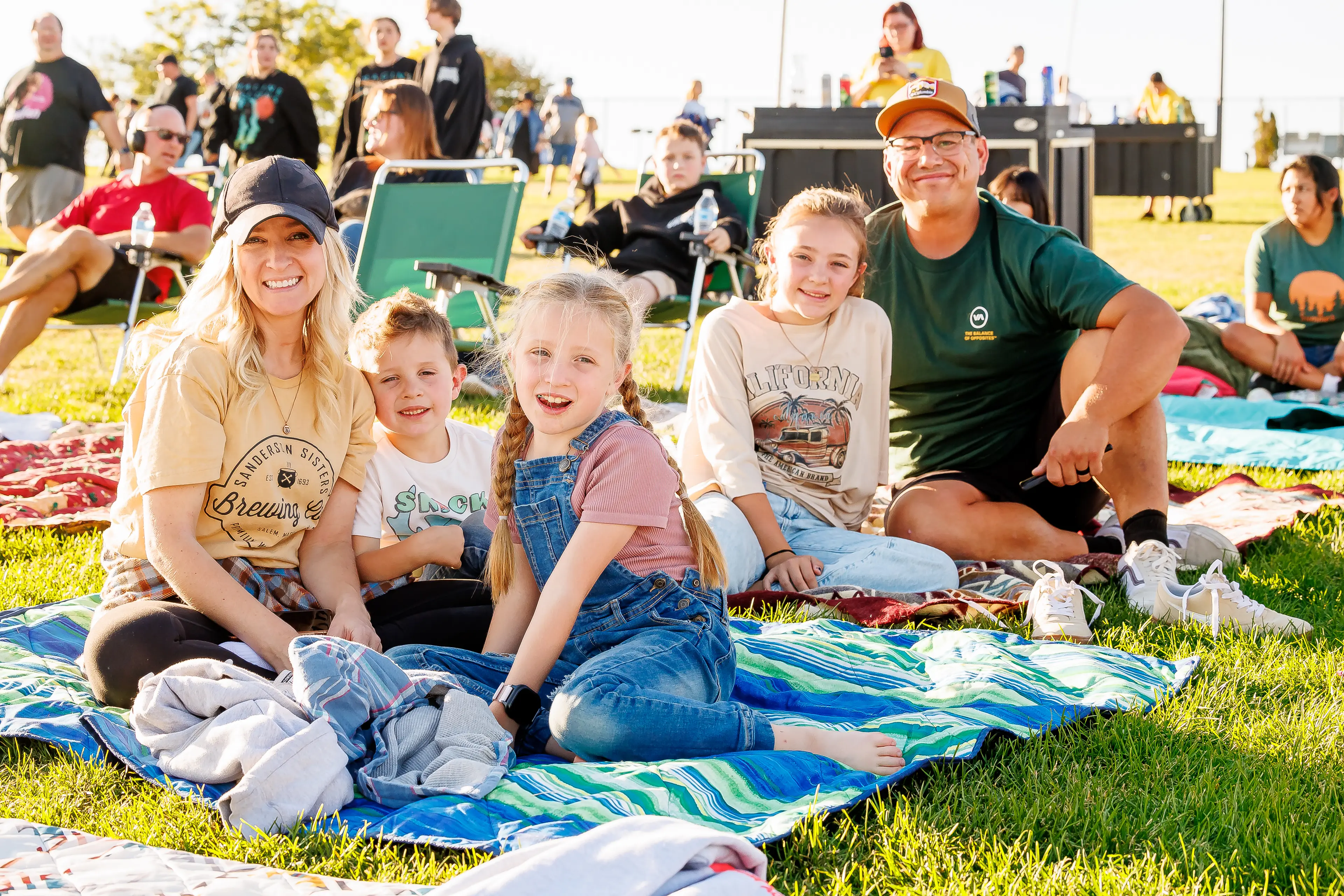 A family sitting on the lawn at a show