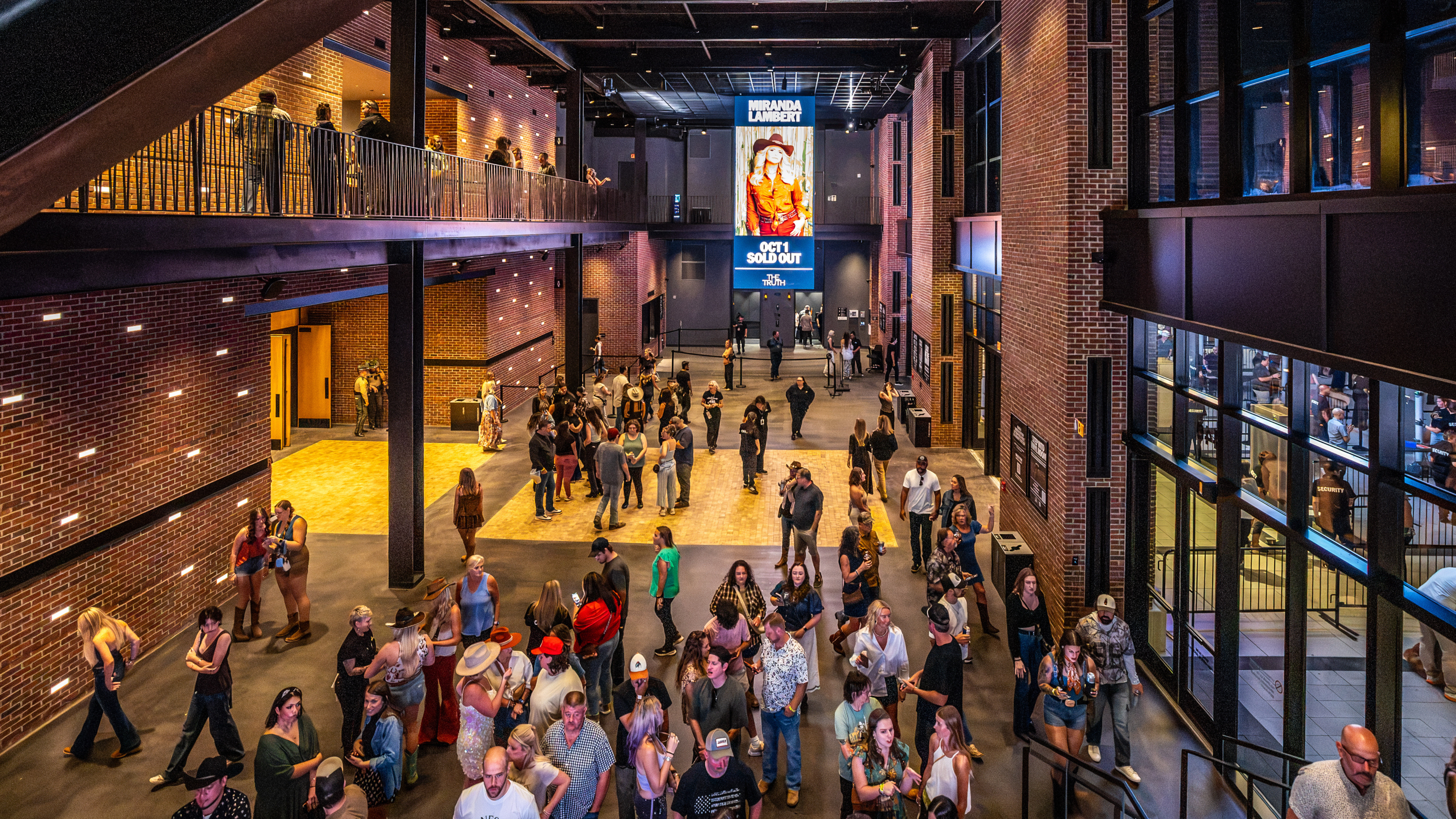Guests gather in The Truth’s brick-lined lobby beneath a Miranda Lambert event sign. Photo credit: Alive Coverage