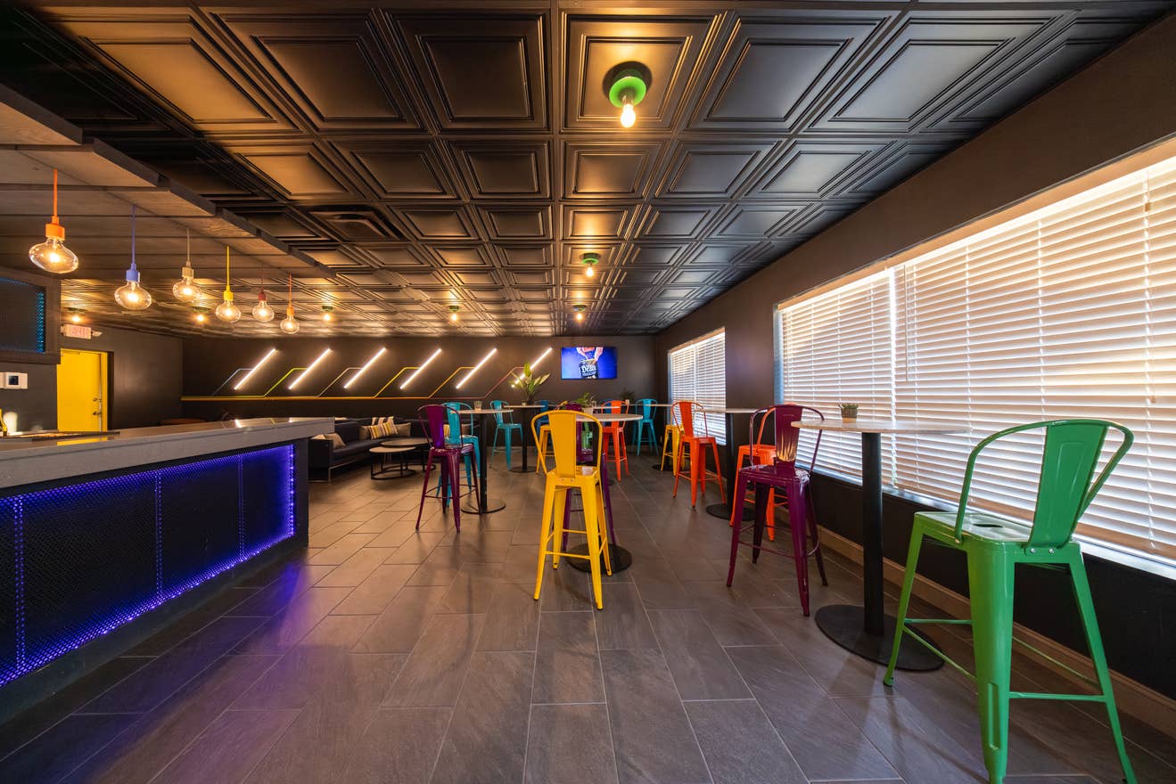 A look inside the Green Room at Hollywood Casino Amphitheater shows colorful chairs with bar tables, a private bar and more.