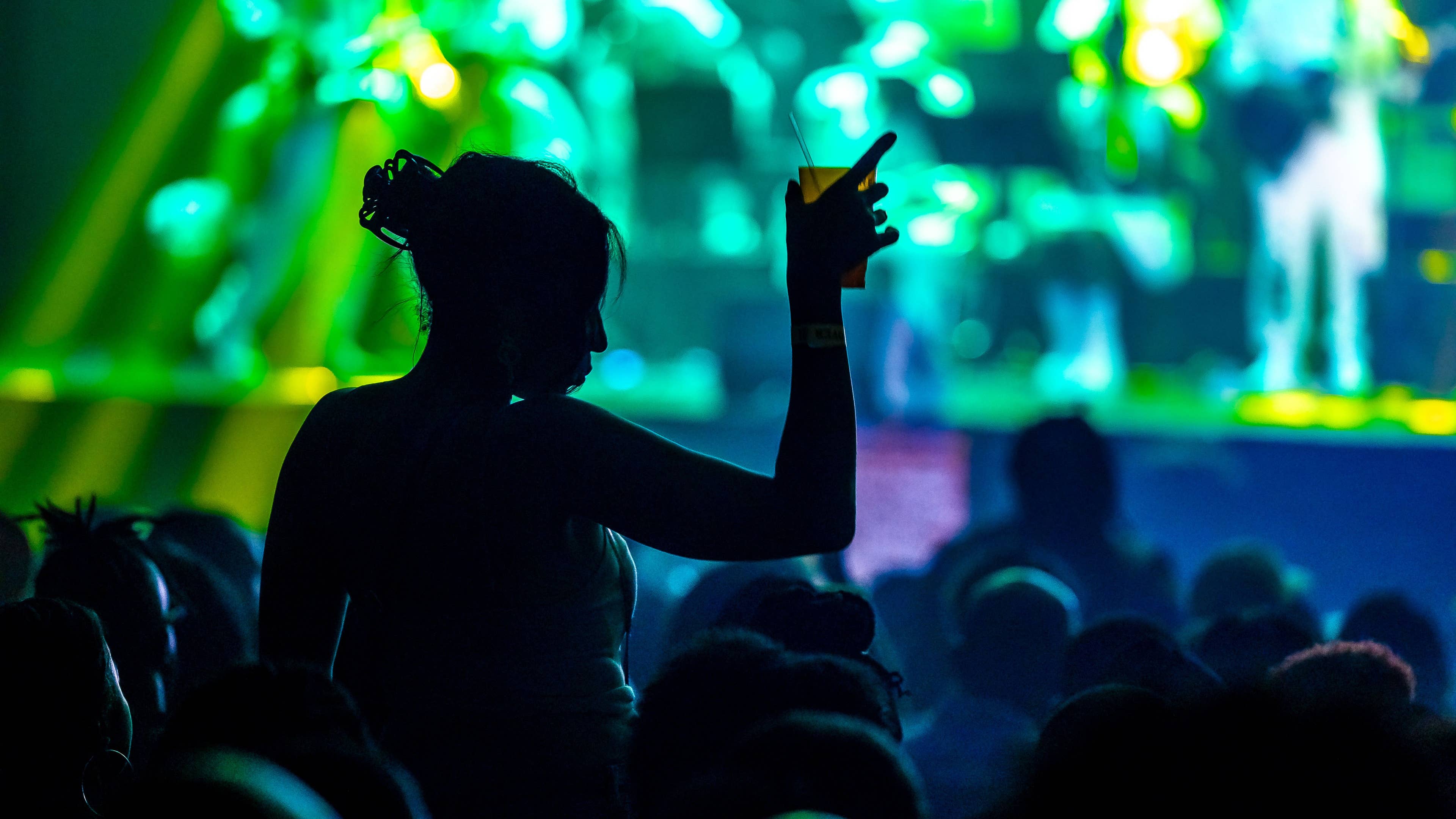 A fan enjoying a concert holding a drink
