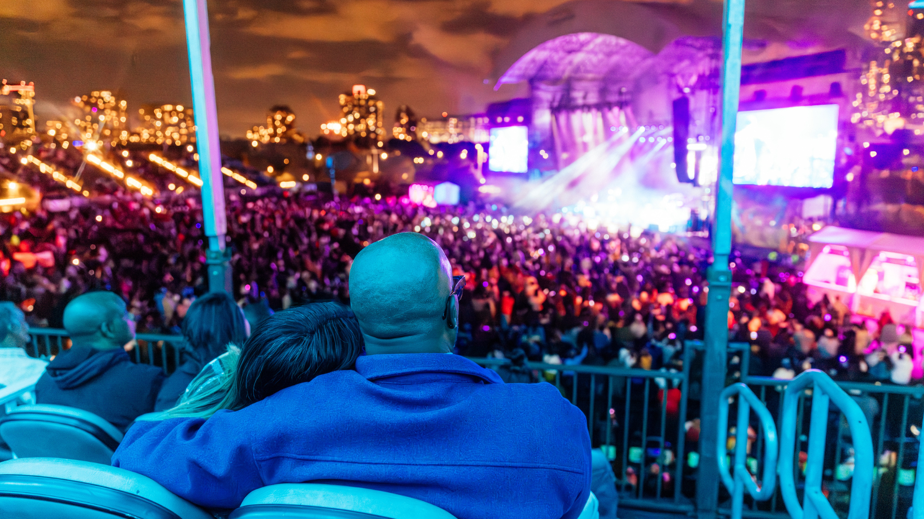 Two people sit in box seats watching the show. 